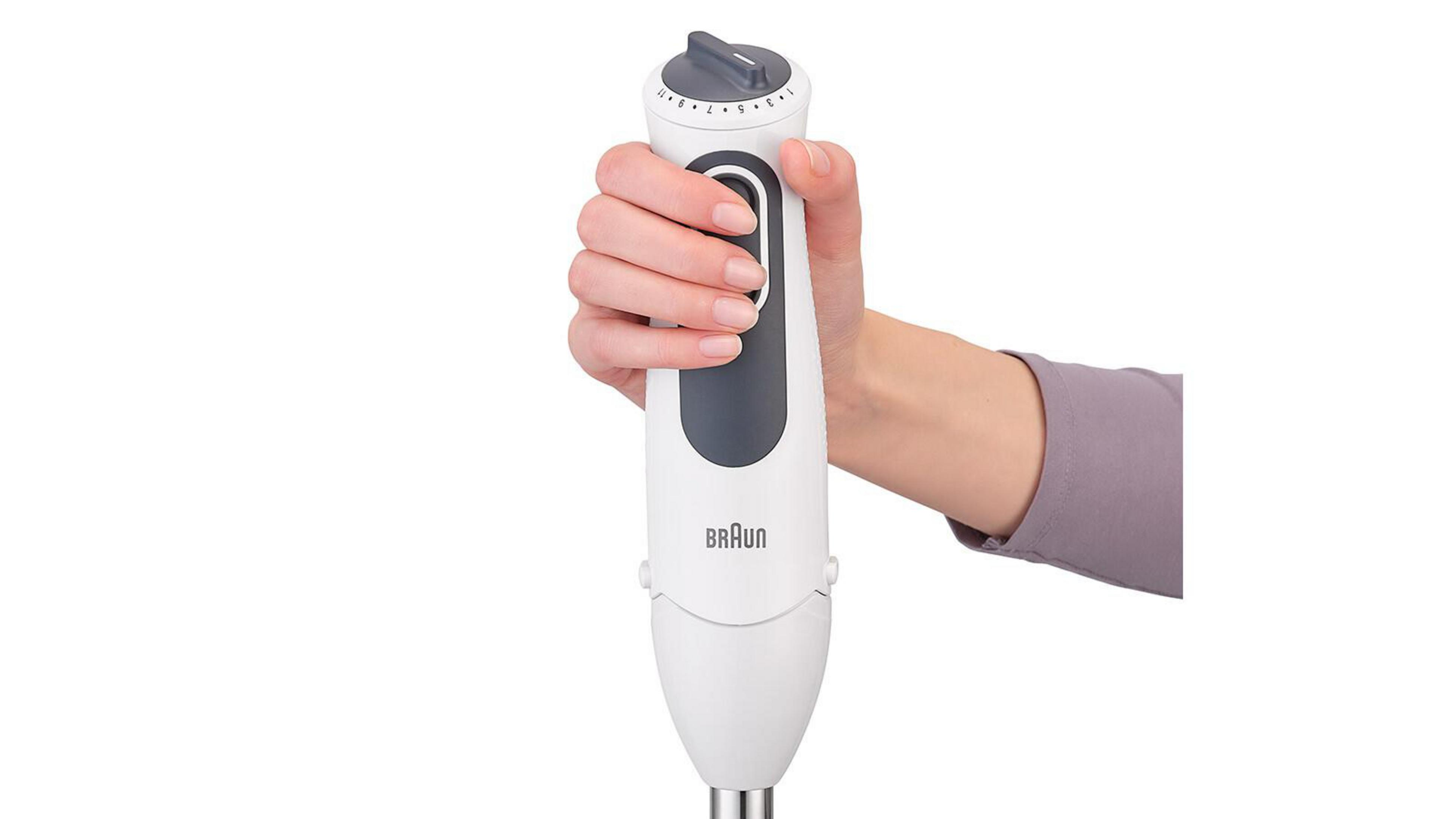 Ręka trzyma biało-szary blender ręczny Braun.