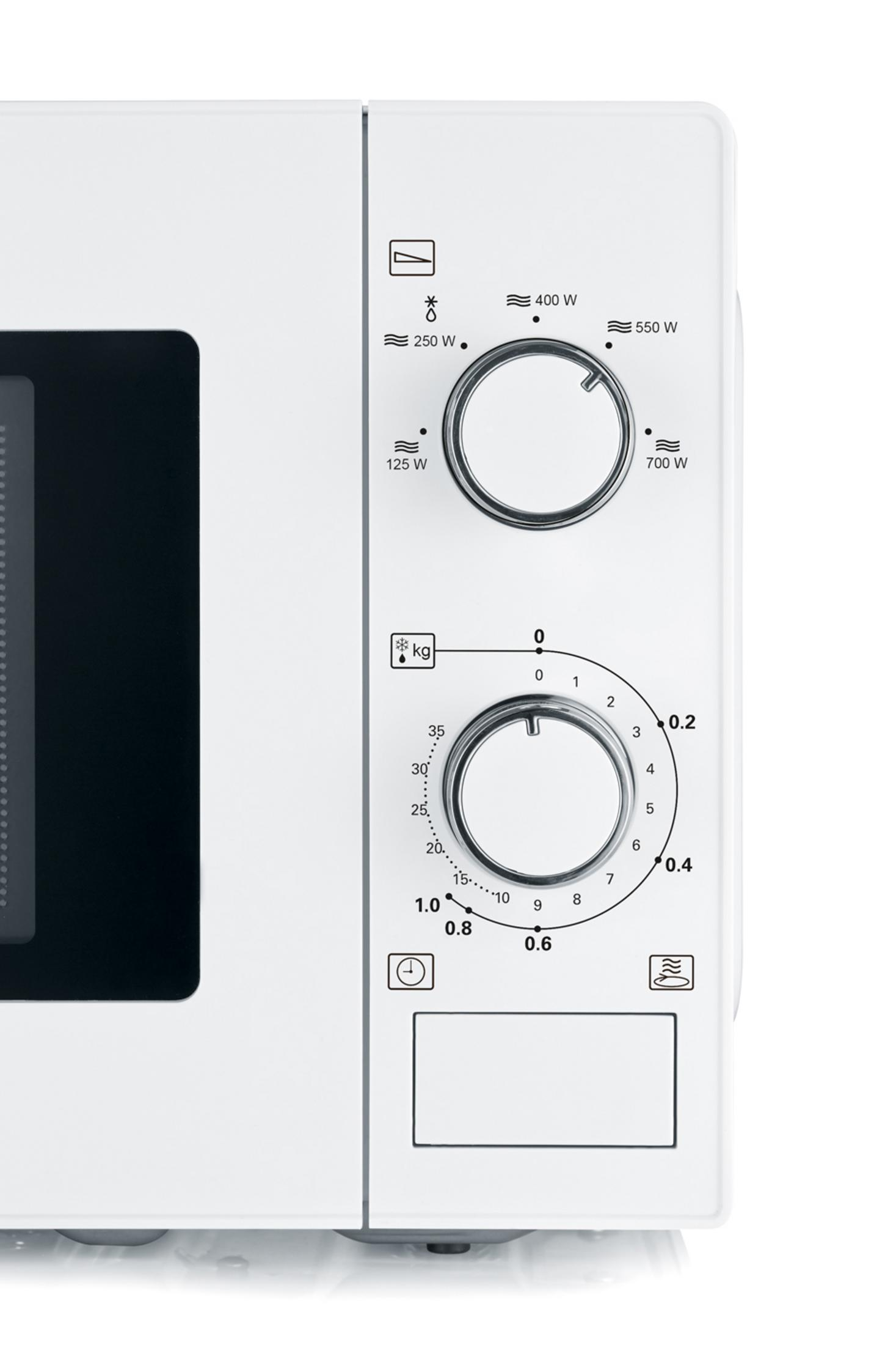 Gros plan sur un micro-ondes blanc avec des cadrans pour les réglages de puissance et de temps.