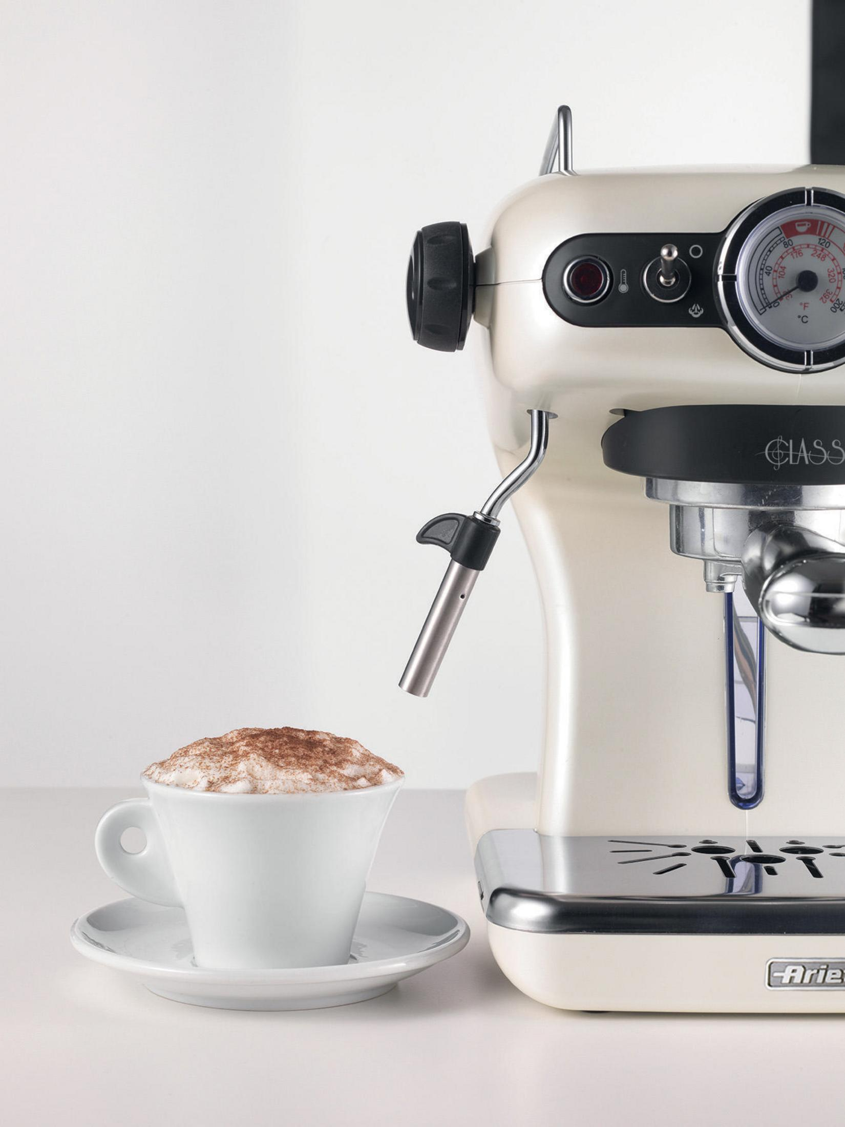 Máquina de espresso crema con una taza de capuchino. El fondo es blanco.