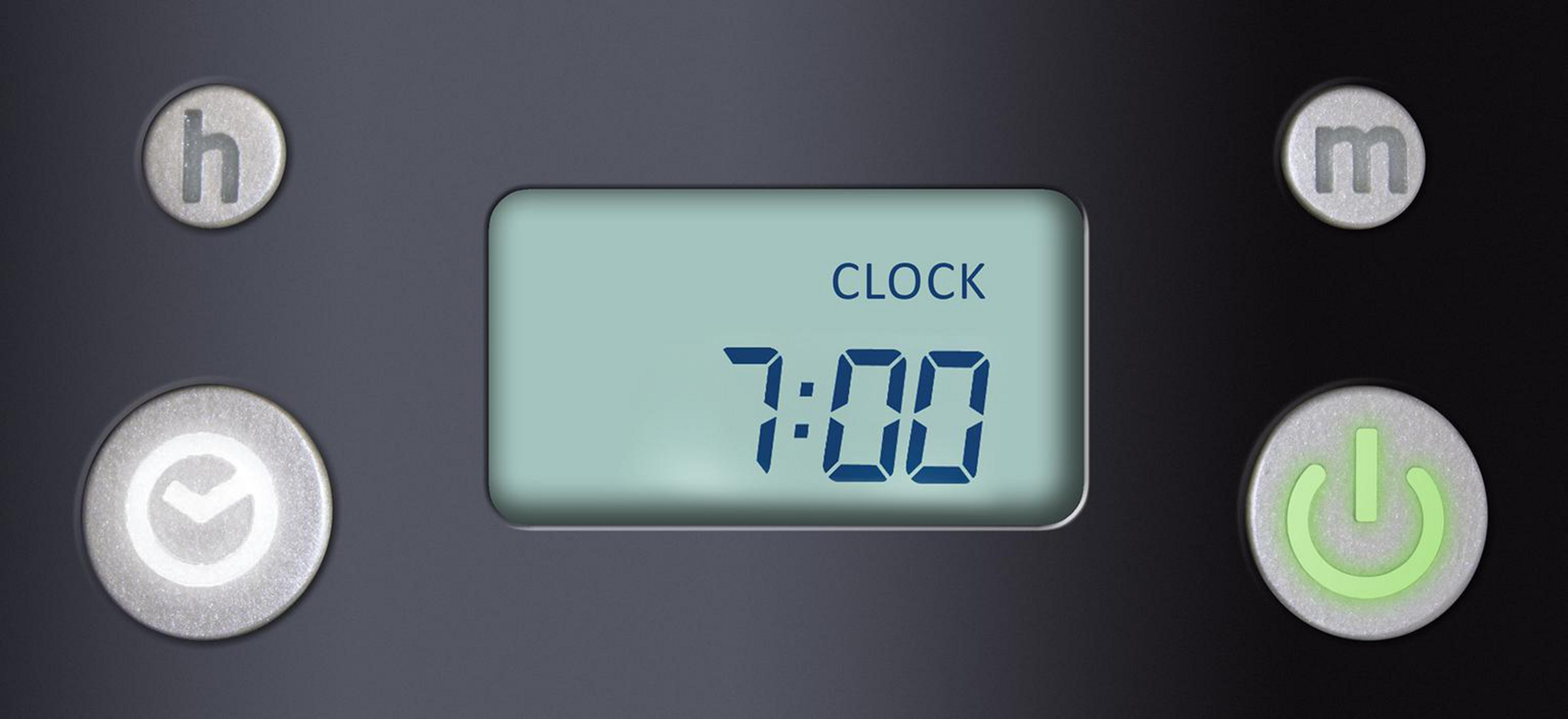 Wyświetlacz cyfrowy pokazujący zegar ustawiony na 7:00 z przyciskami dla godziny, czasu i zasilania.