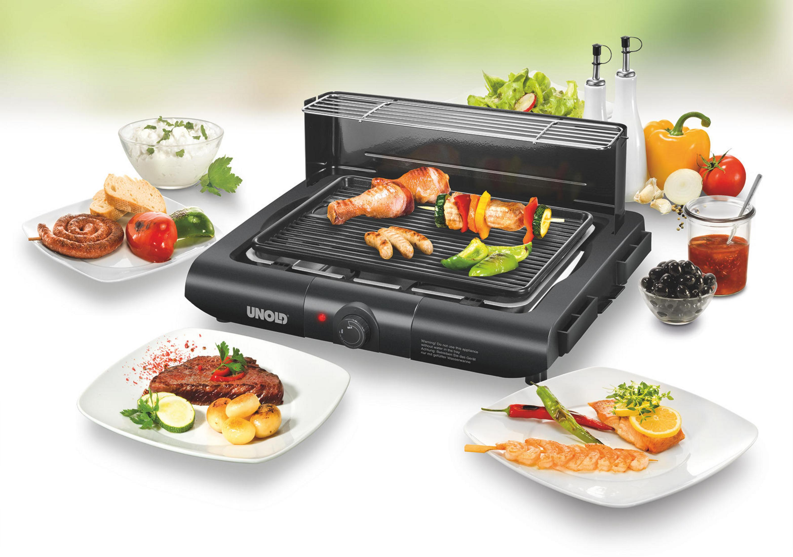 Ein schwarzer Unold-Grill mit verschiedenen gegarten Speisen auf Tellern und Spießen.