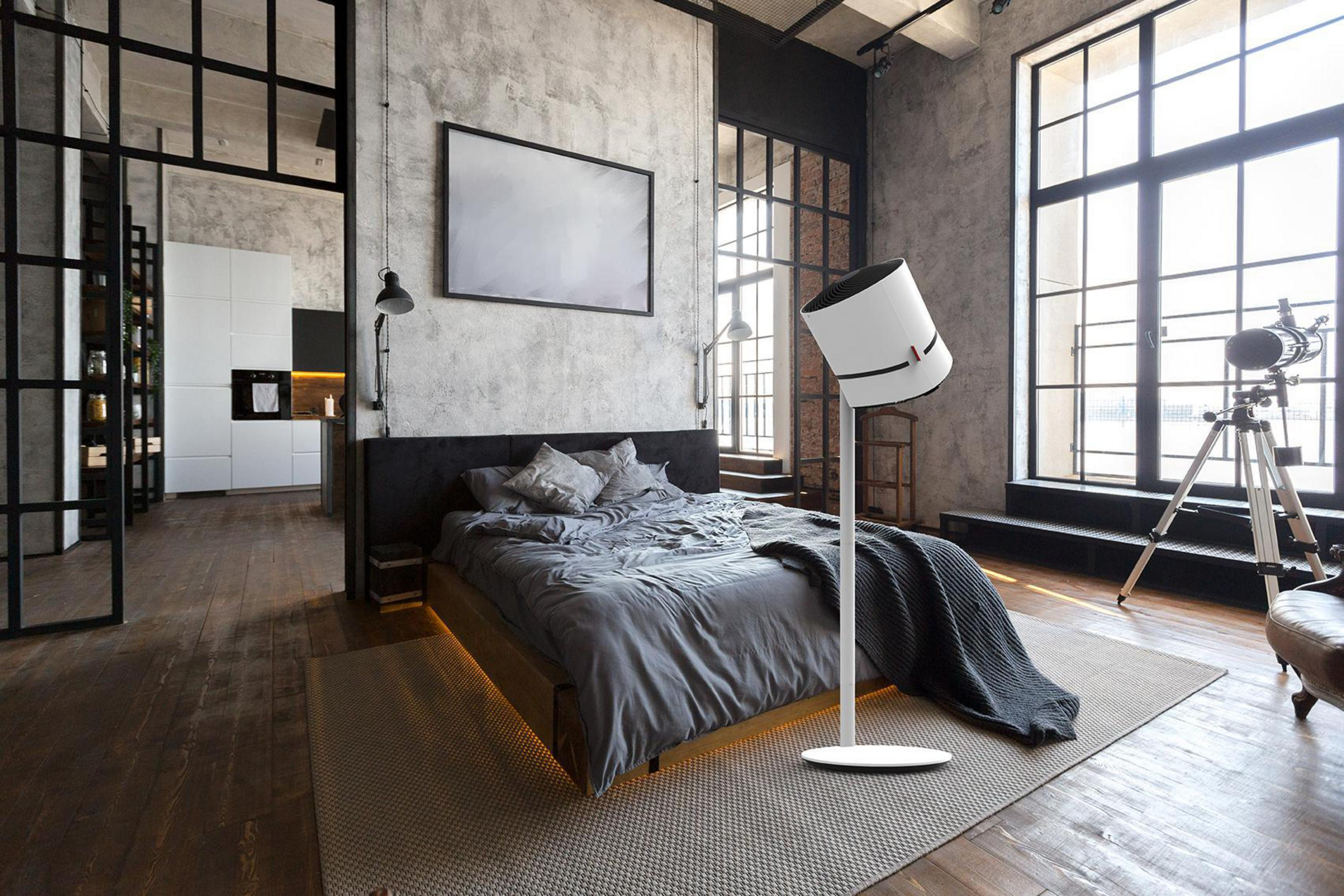 Une chambre avec lit, lampe et grande fenêtre.
