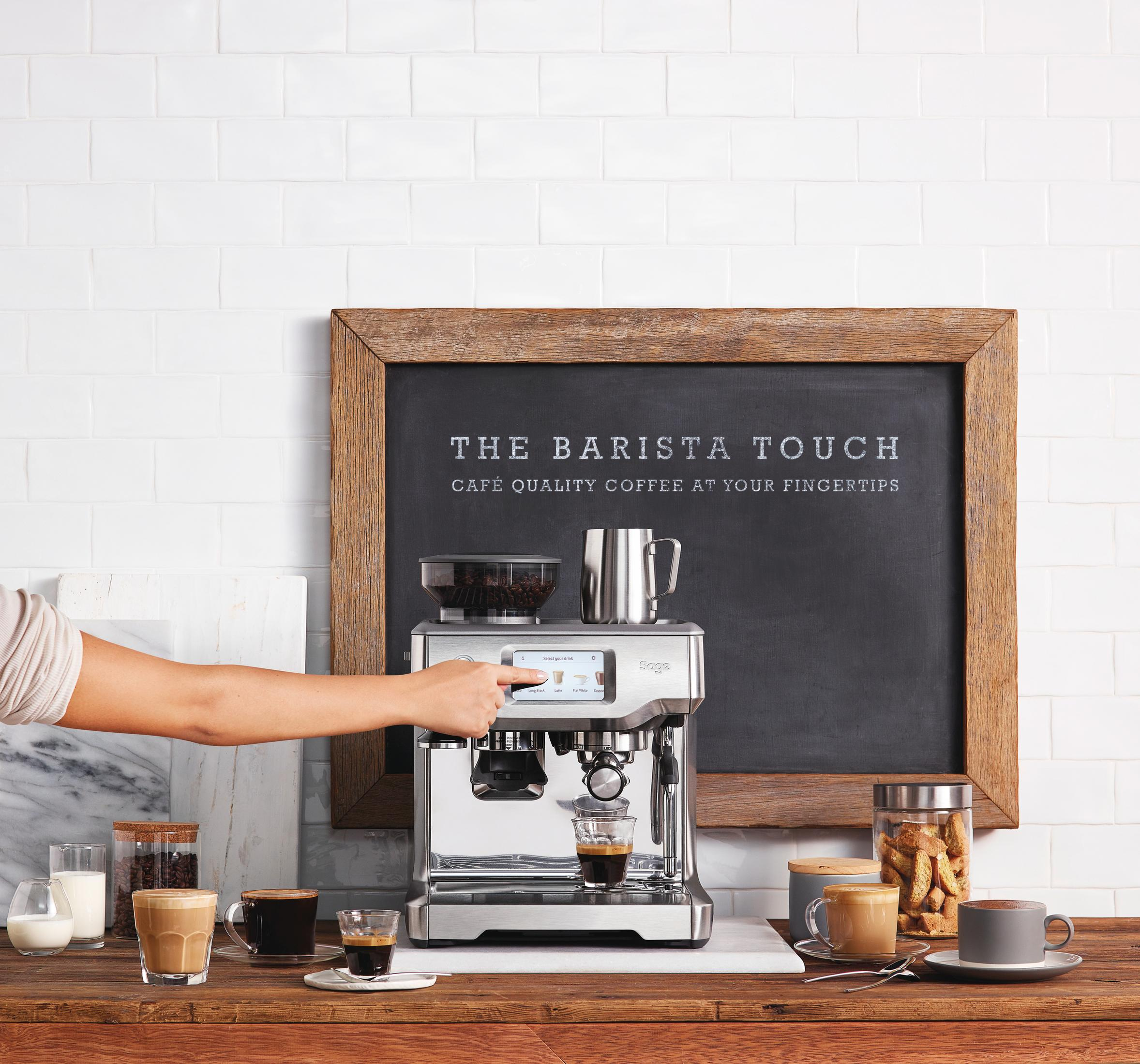 Barista używający ekspresu do kawy z tablicą w tle.