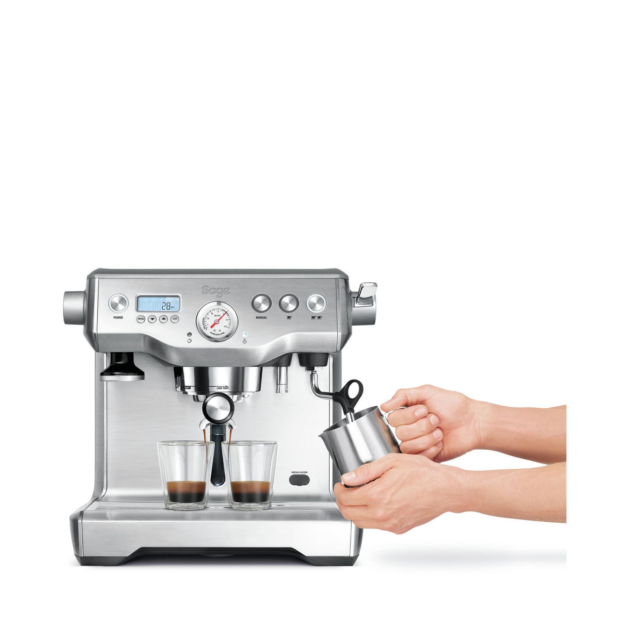 Espressomaschine, zwei Shots werden gegossen, Person hält Milchschaumkännchen.