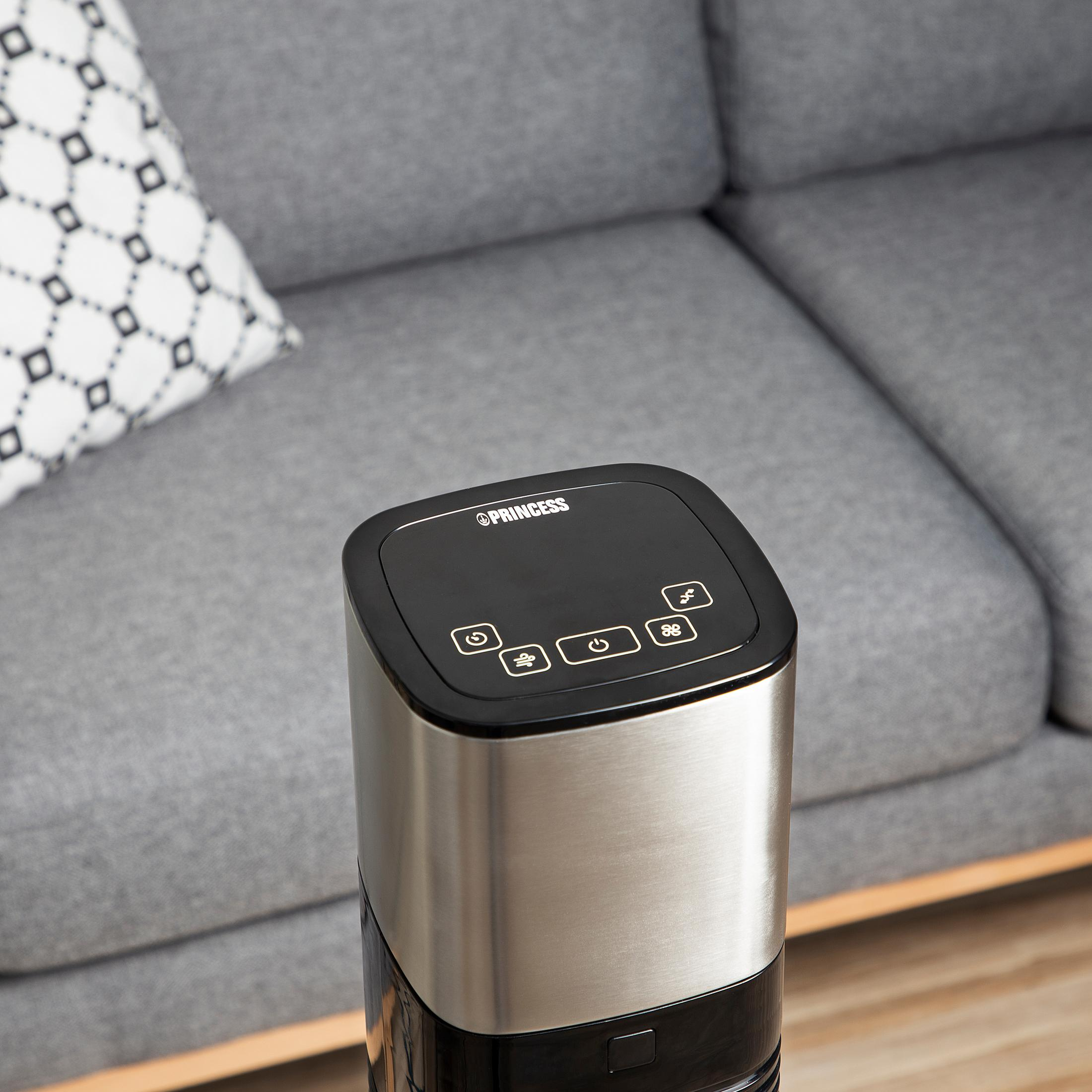 Czarny i srebrny oczyszczacz powietrza Princess na szarym tle kanapy.
