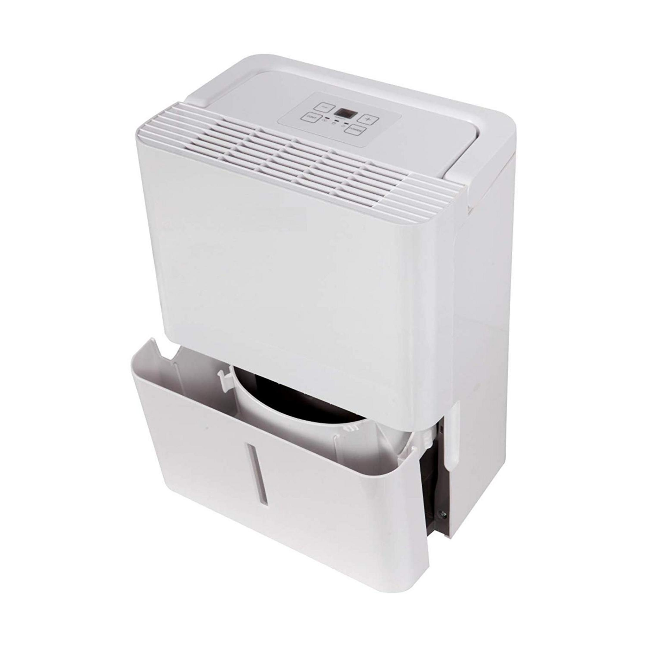 Biały osuszacz powietrza z otwartym zbiornikiem na wodę. Na górze znajdują się przyciski sterowania i otwory wentylacyjne.