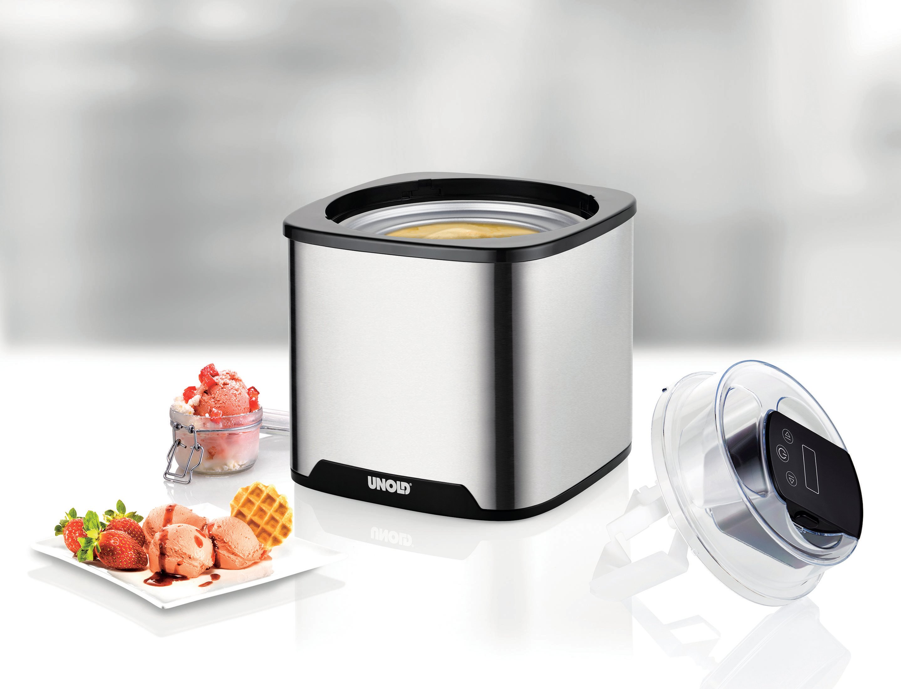 Srebrna maszyna do lodów z akcesoriami: lody, gofry, truskawki i łyżka.