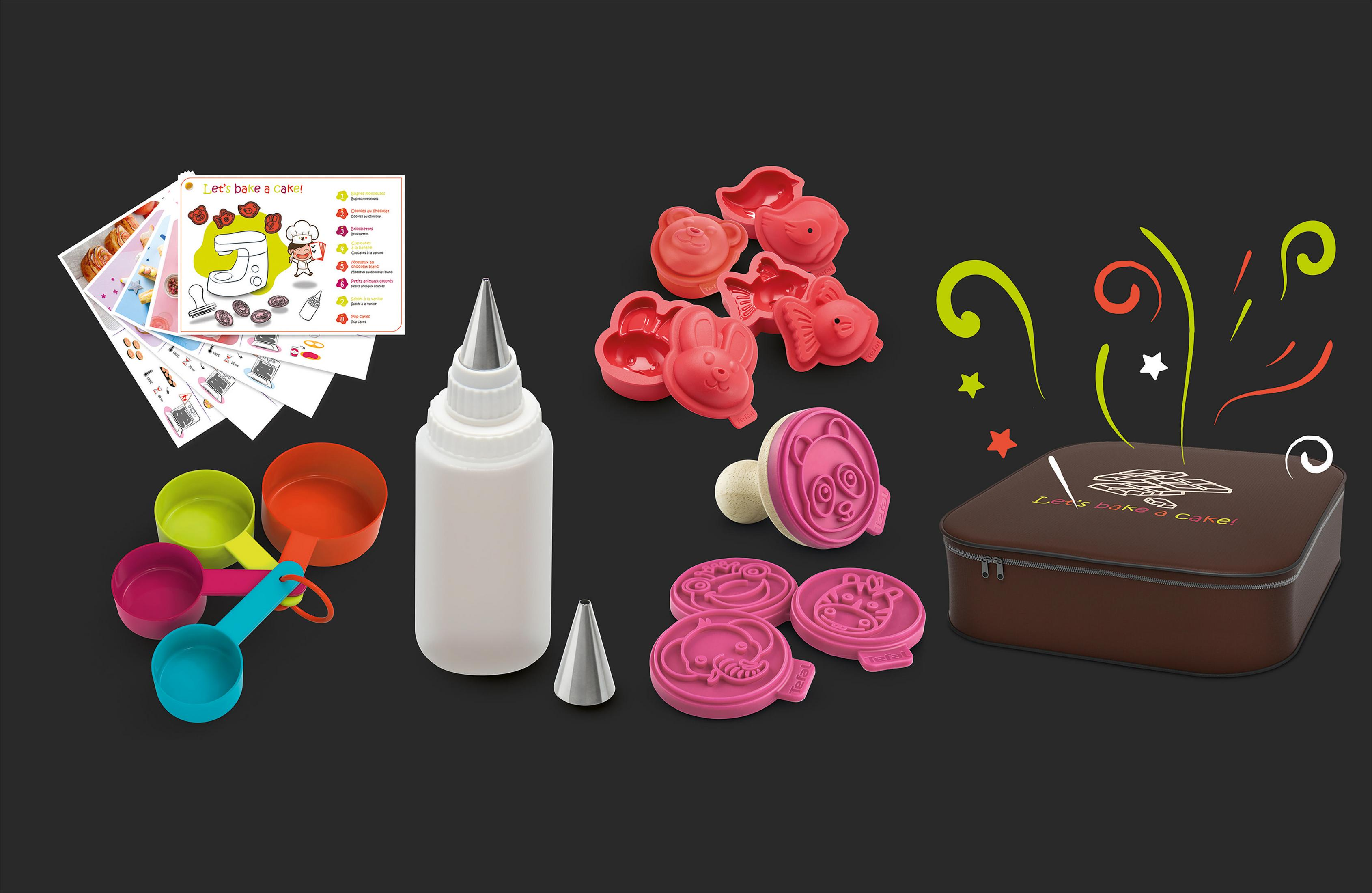 Kit per la cottura con stampi, misurini, bottiglia per glassa e istruzioni. Sfondo nero.