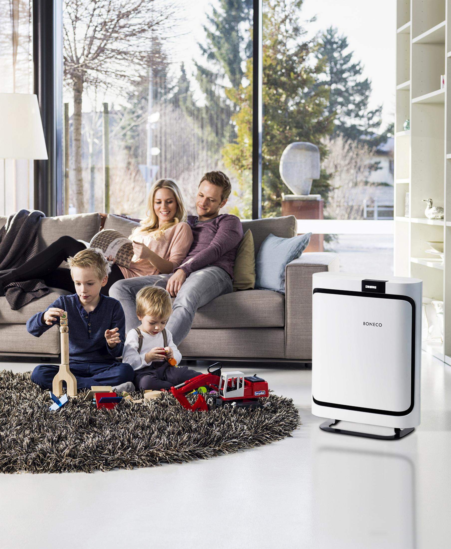 Familia en sala de estar con purificador de aire y juguetes.