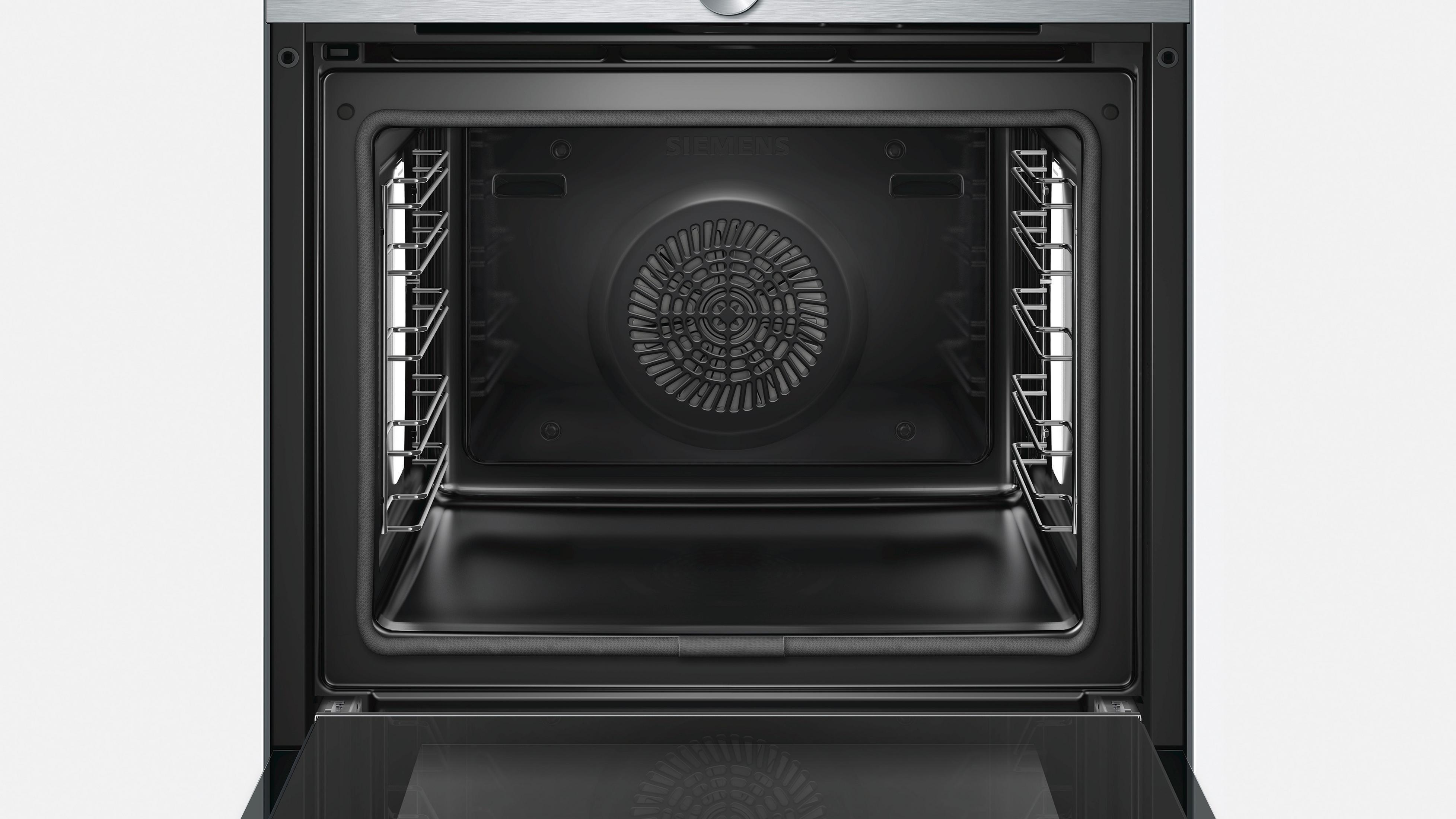 Open oveninterieur met roosters en ventilator. De ovendeur is open. Zwart en metallic design.