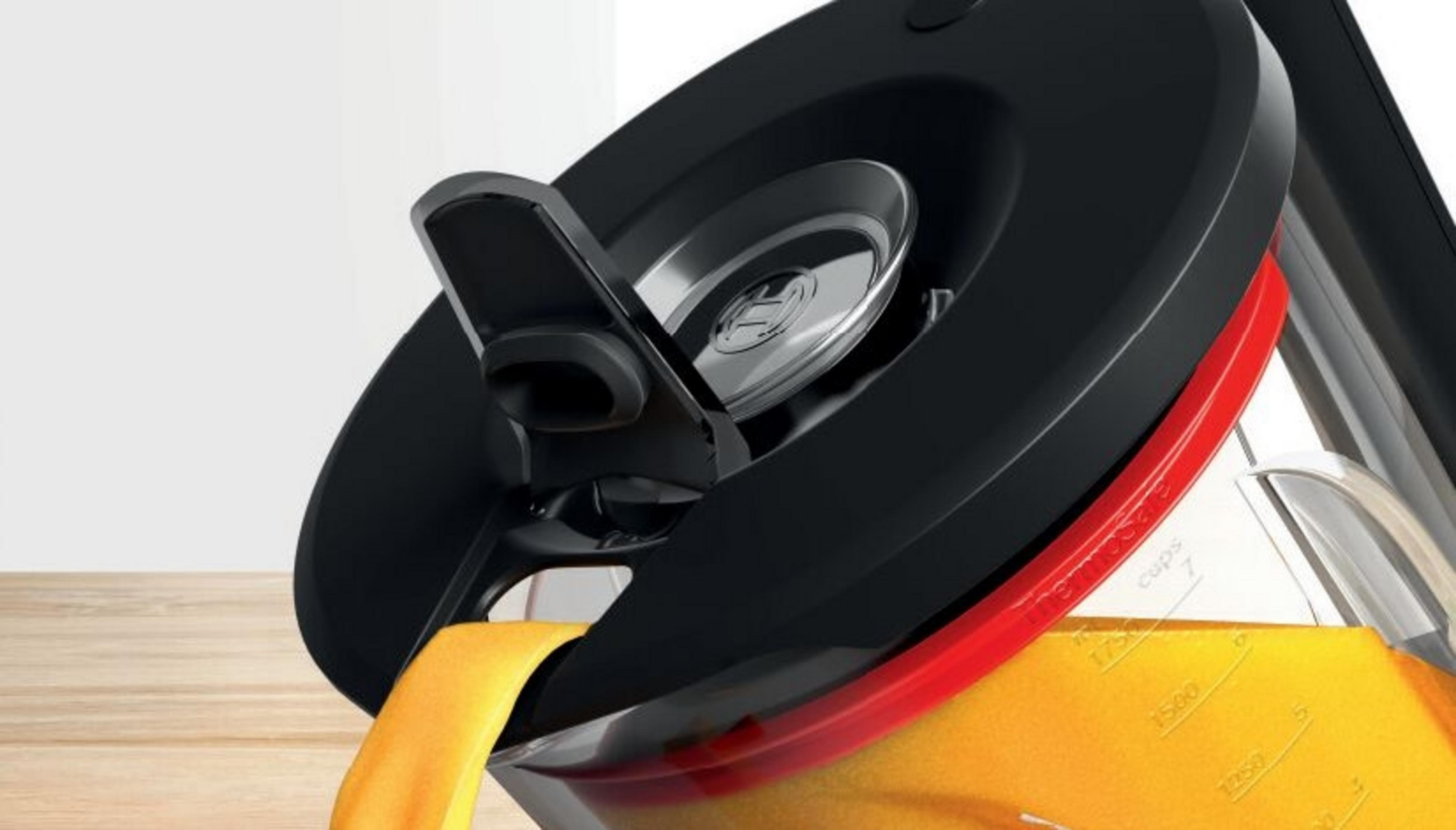 Zbliżenie czarnej pokrywy z wylewką, prawdopodobnie z urządzenia kuchennego.