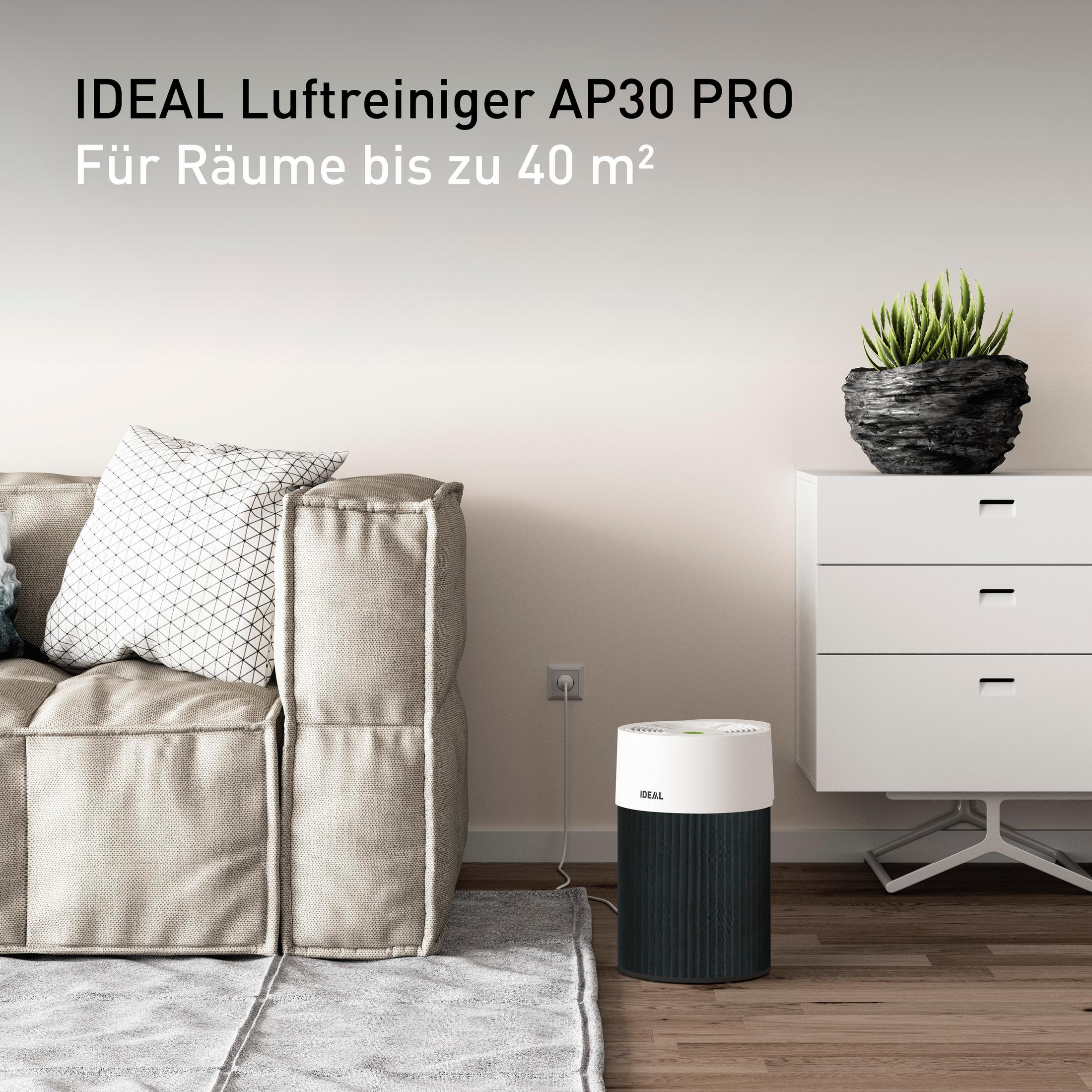 Luftreiniger neben einer Couch. Text: IDEAL Luftreiniger AP30 PRO. Weiß und schwarz.