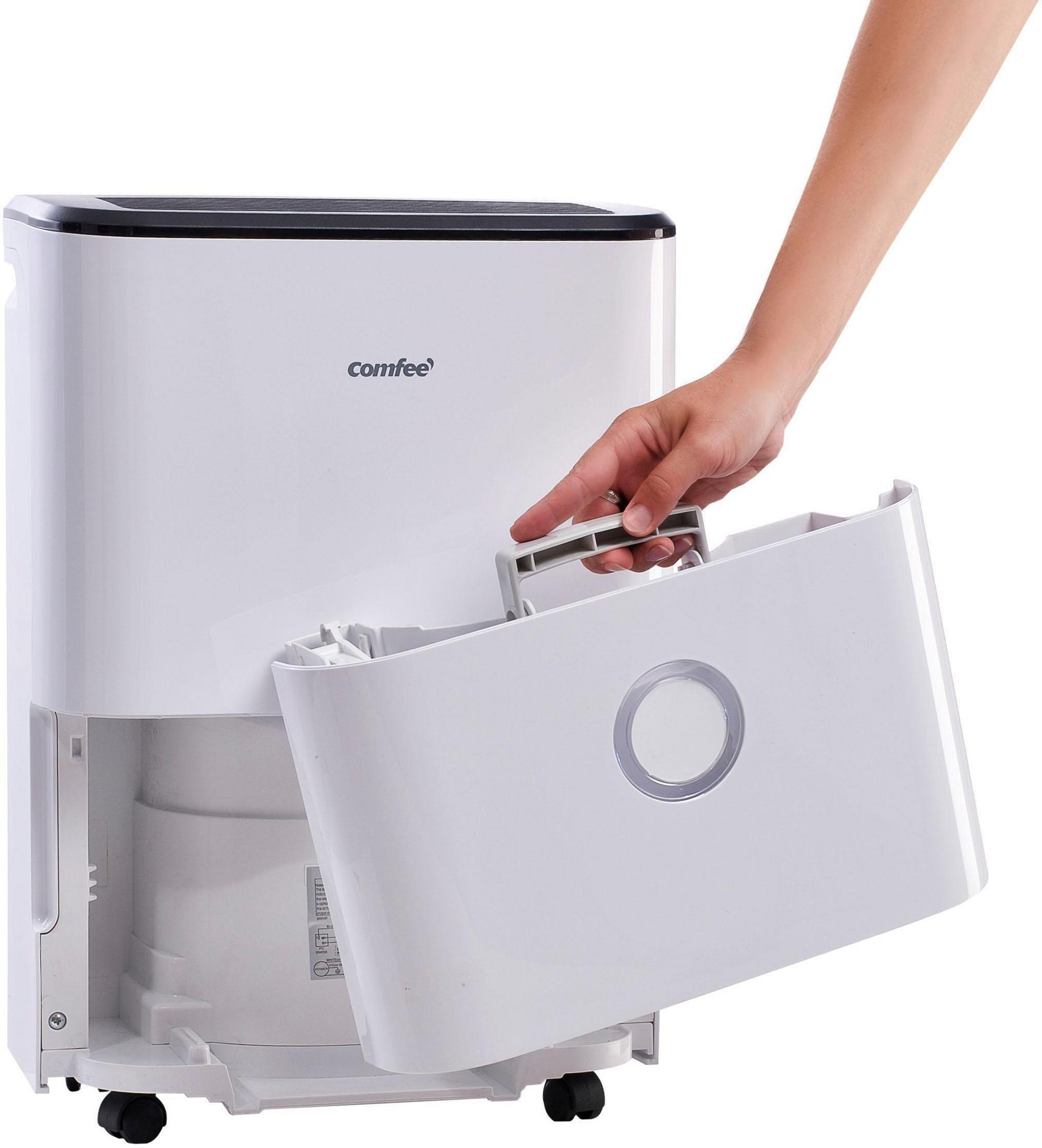 Ręka osoby wyjmuje zbiornik na wodę z białego osuszacza powietrza.