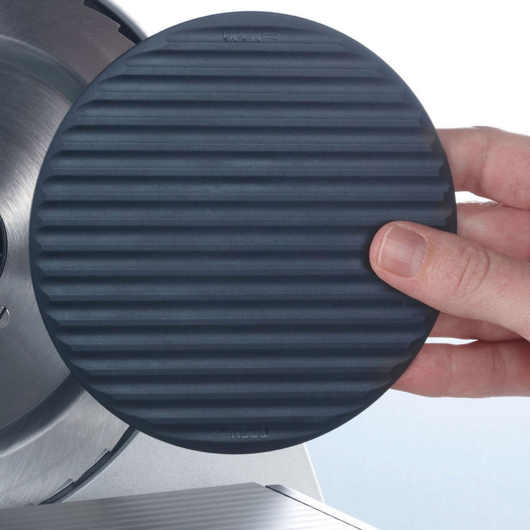 Un disco di gomma nero con scanalature, tenuto da una mano.