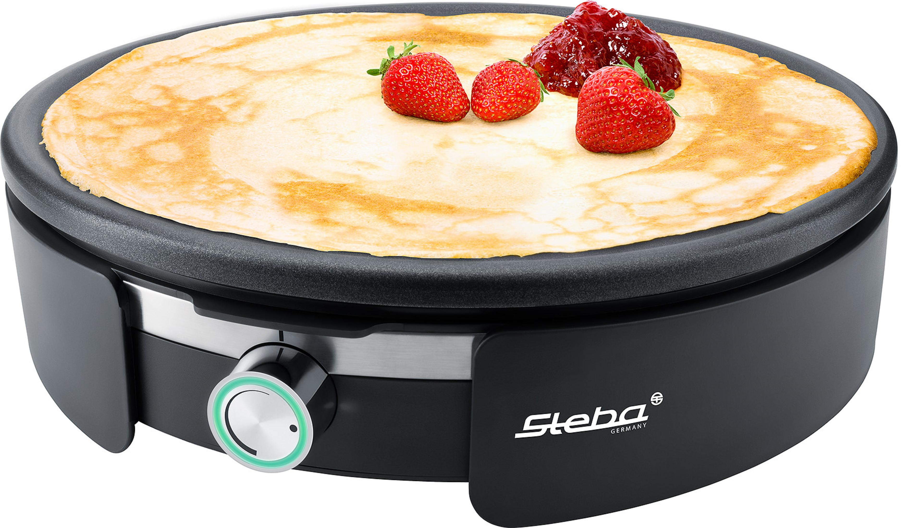 Ein schwarzer Crêpes-Maker mit einem Crêpe darauf, garniert mit Erdbeeren und Marmelade.