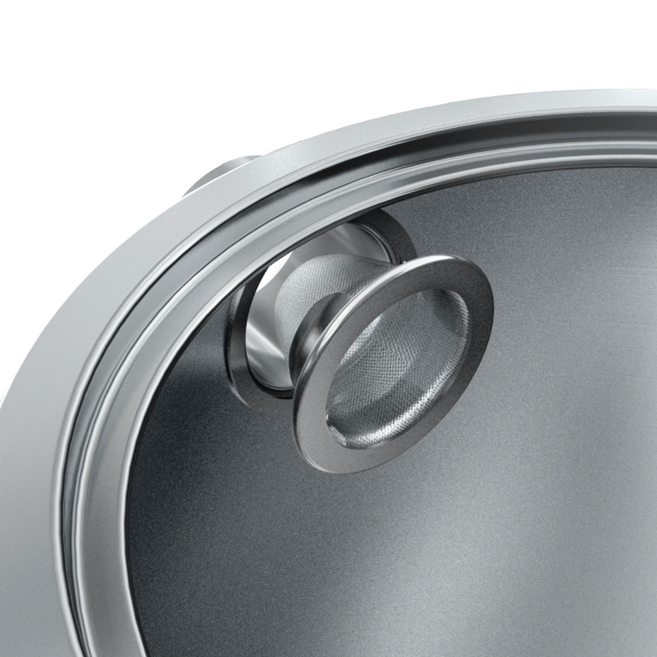 RVS thee-infuser in een waterkoker. Close-up, bovenaanzicht.
