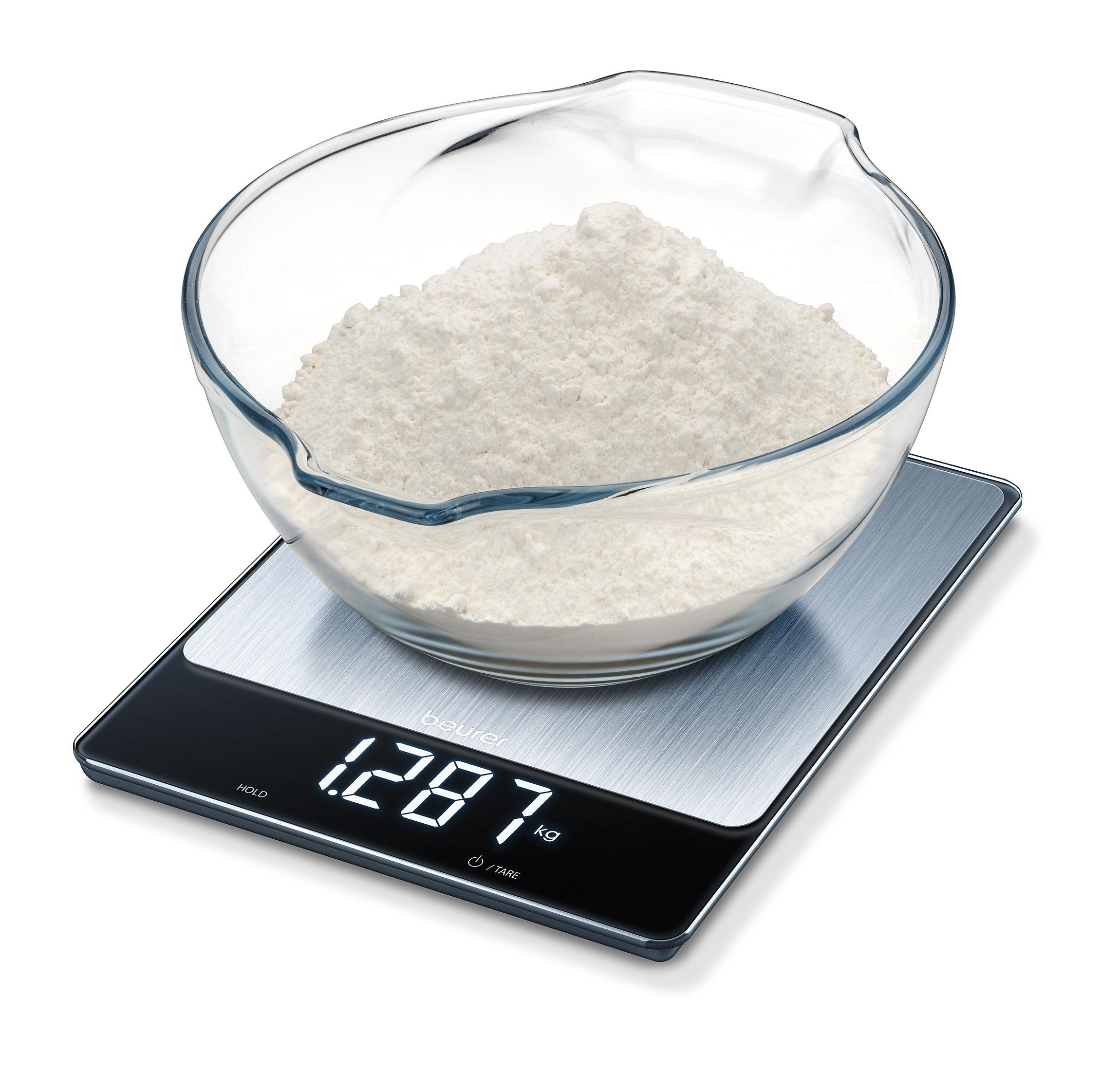 Eine Glasschüssel mit Mehl auf einer digitalen Küchenwaage, auf der 1287 kg angezeigt werden.