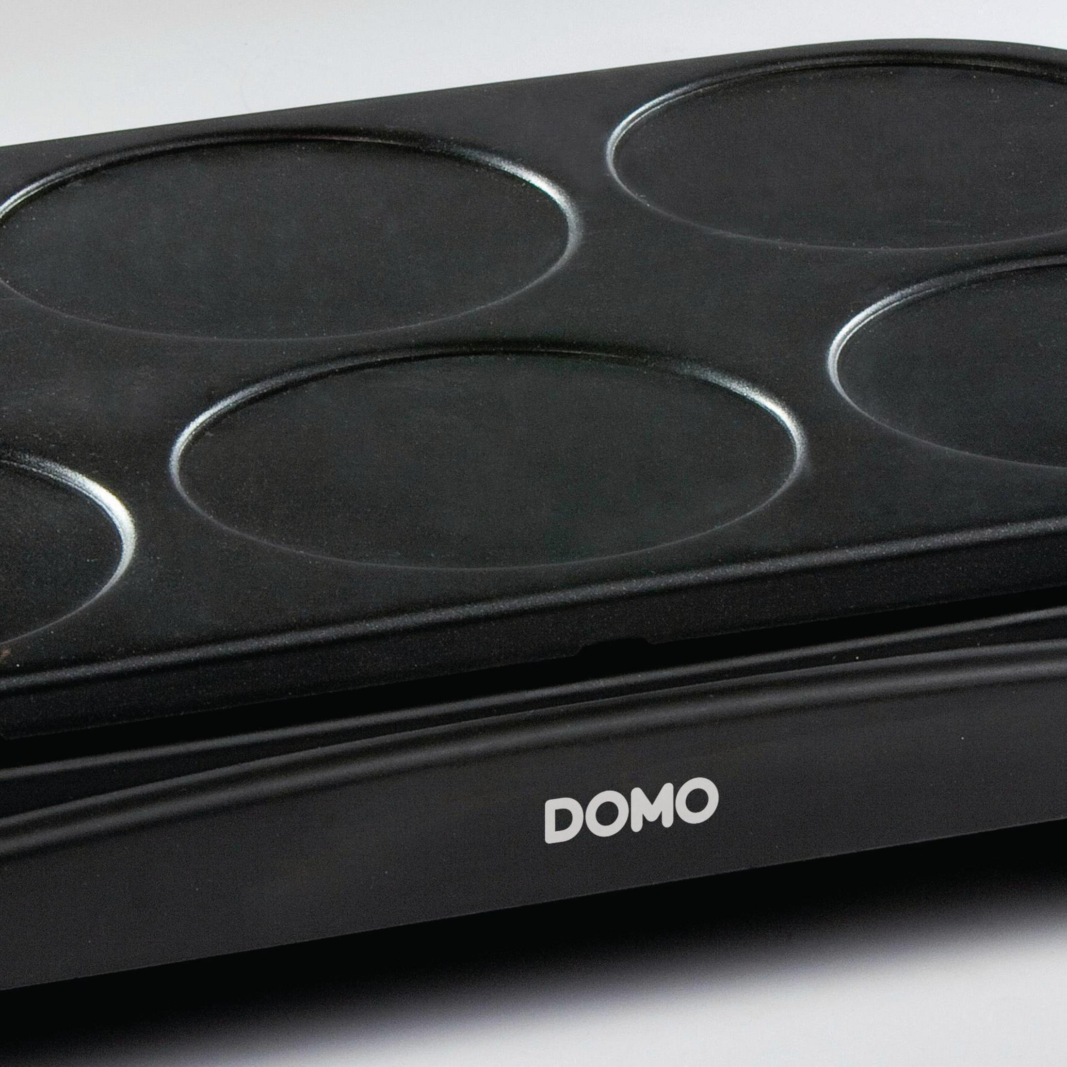Czarny naleśnikarka z sześcioma okrągłymi powierzchniami do gotowania. Napis DOMO.