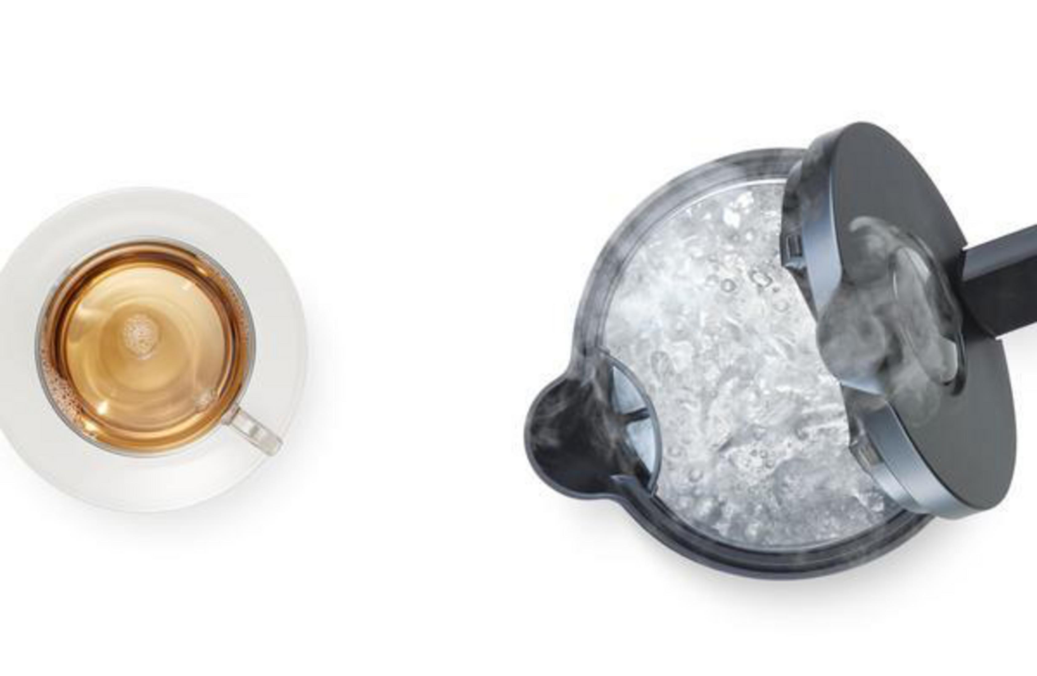 Widok z góry na filiżankę herbaty i czajnik z wrzącą wodą, para unosi się z otwartej pokrywki.