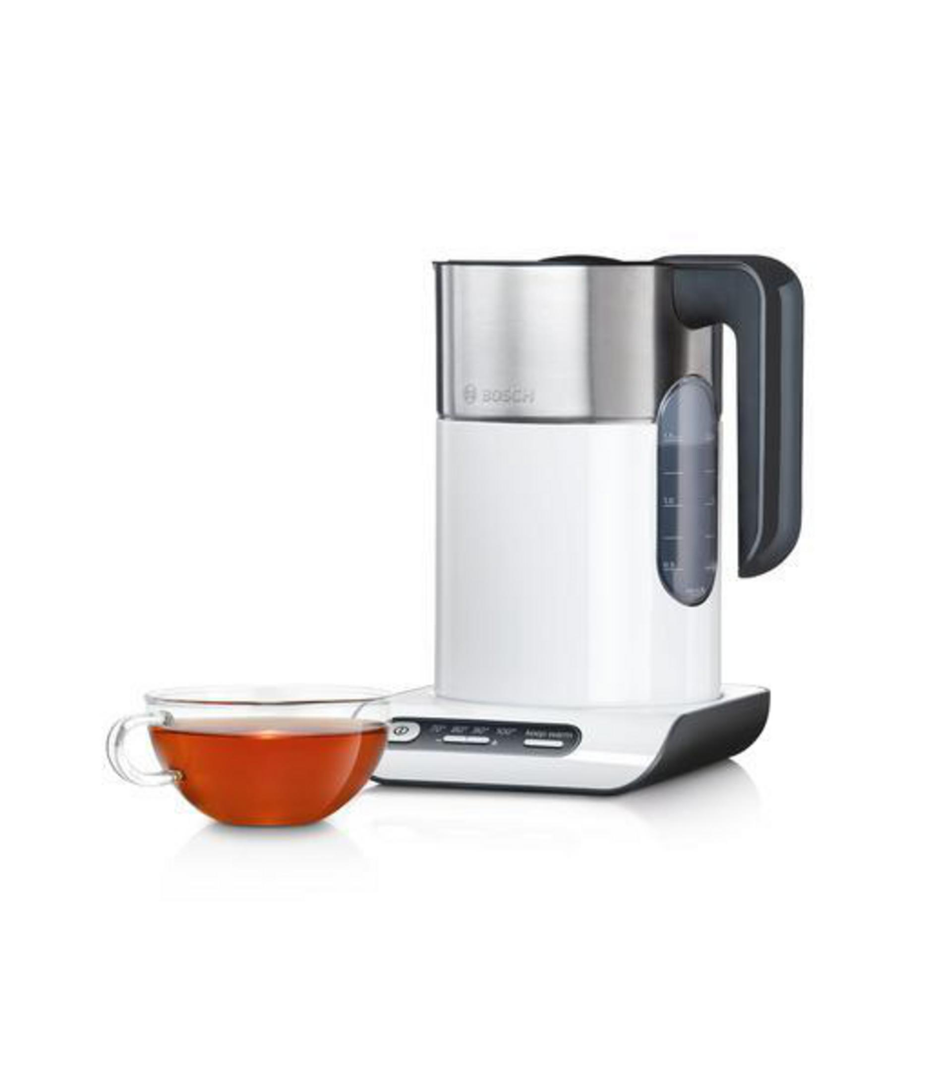 Ein weißer und silberner Bosch Wasserkocher mit Griff, neben einer Tasse Tee.