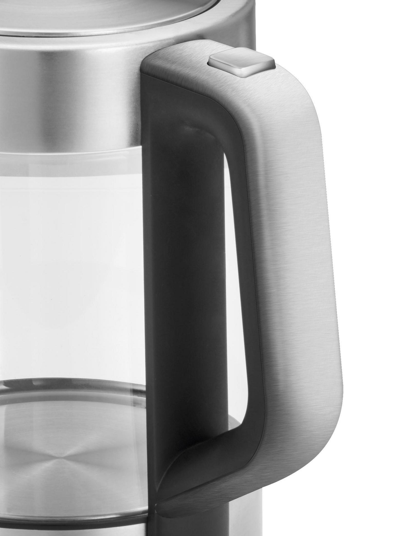 Zbliżenie uchwytu czajnika ze stali nierdzewnej z czarną podstawą i srebrnym przyciskiem.