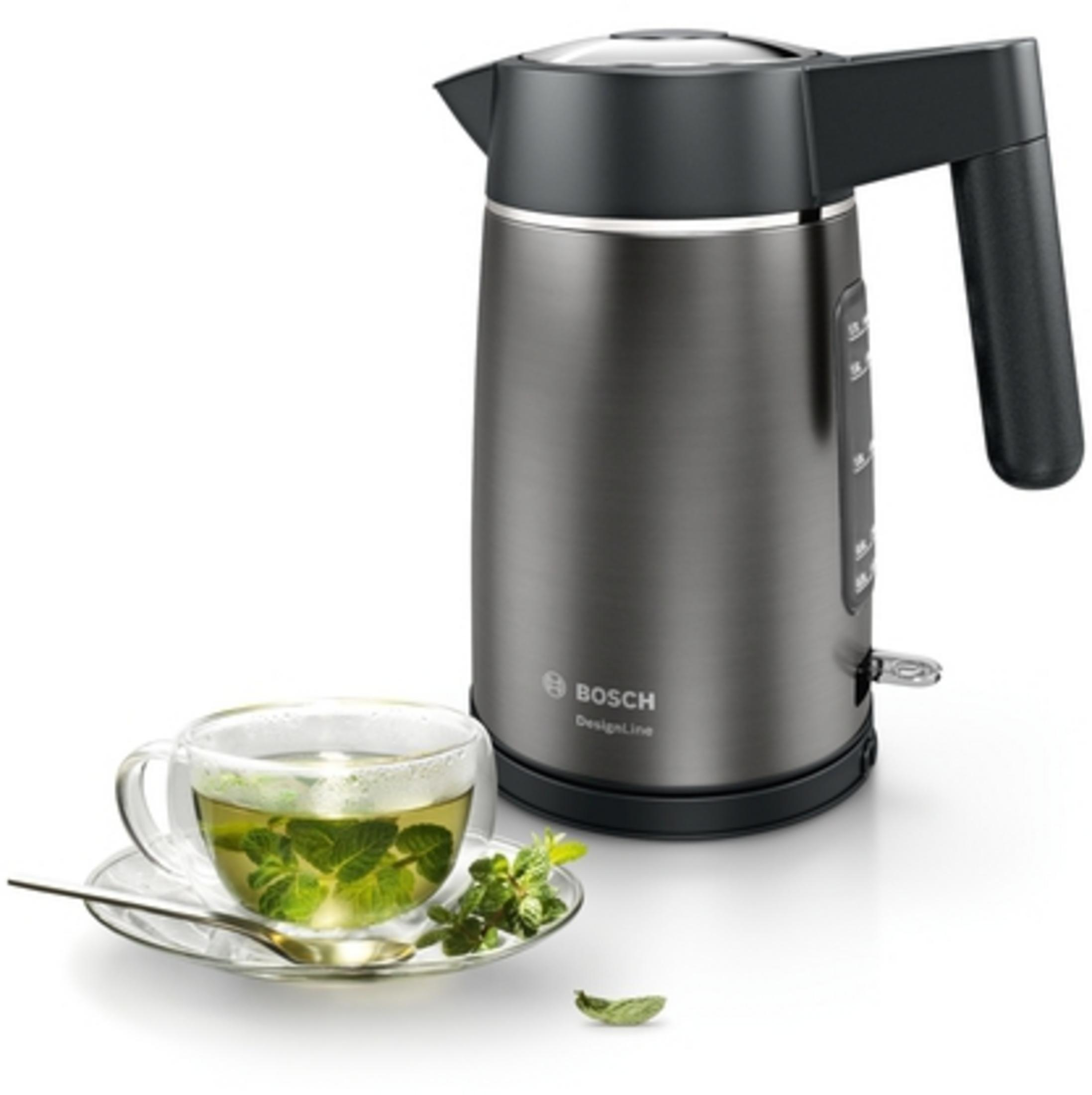 Czajnik elektryczny z filiżanką herbaty z miętą na spodku. Szary czajnik z czarnym uchwytem na białym tle.