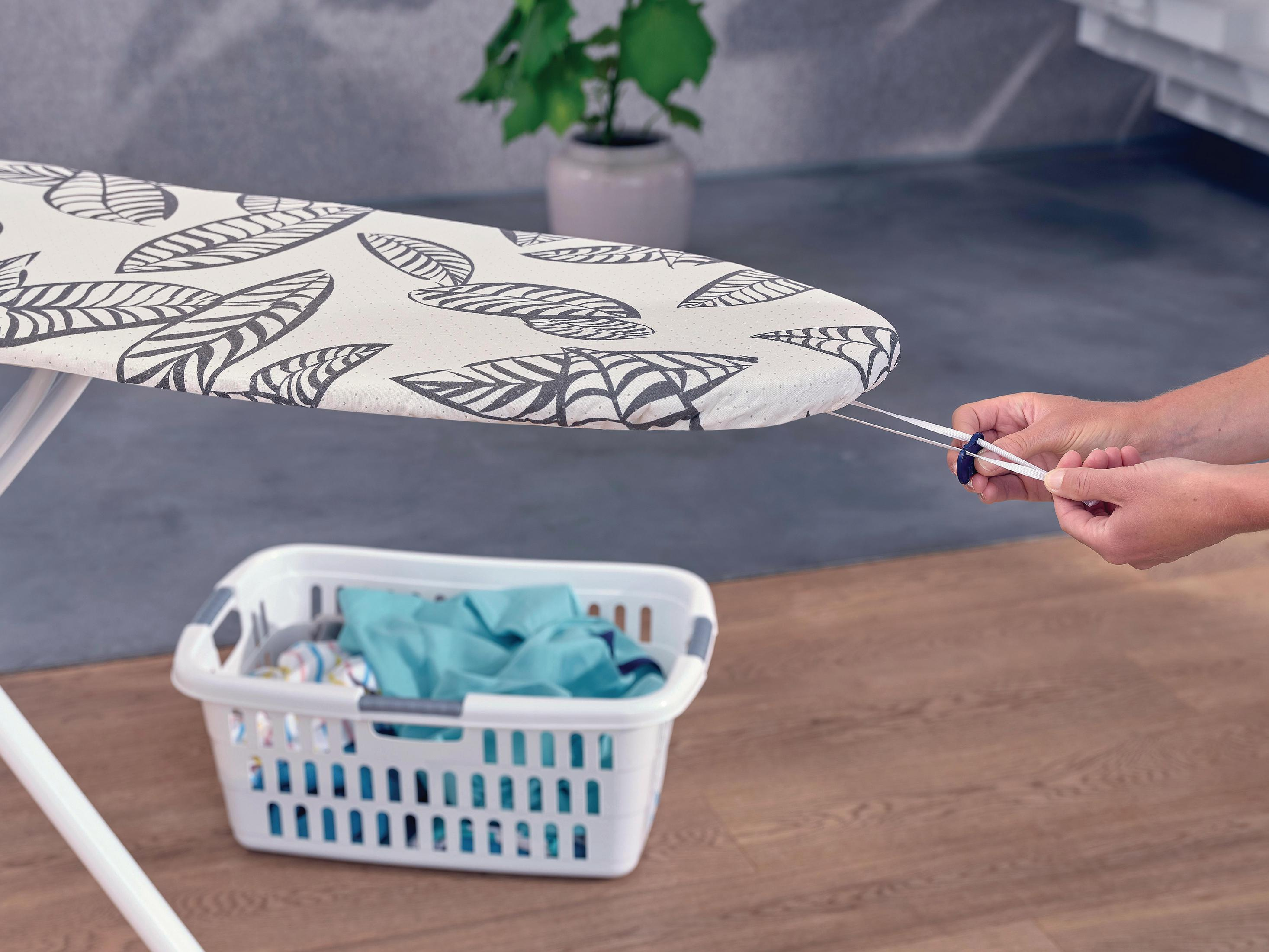 Osoba zaciska sznurek na pokrowcu deski do prasowania.