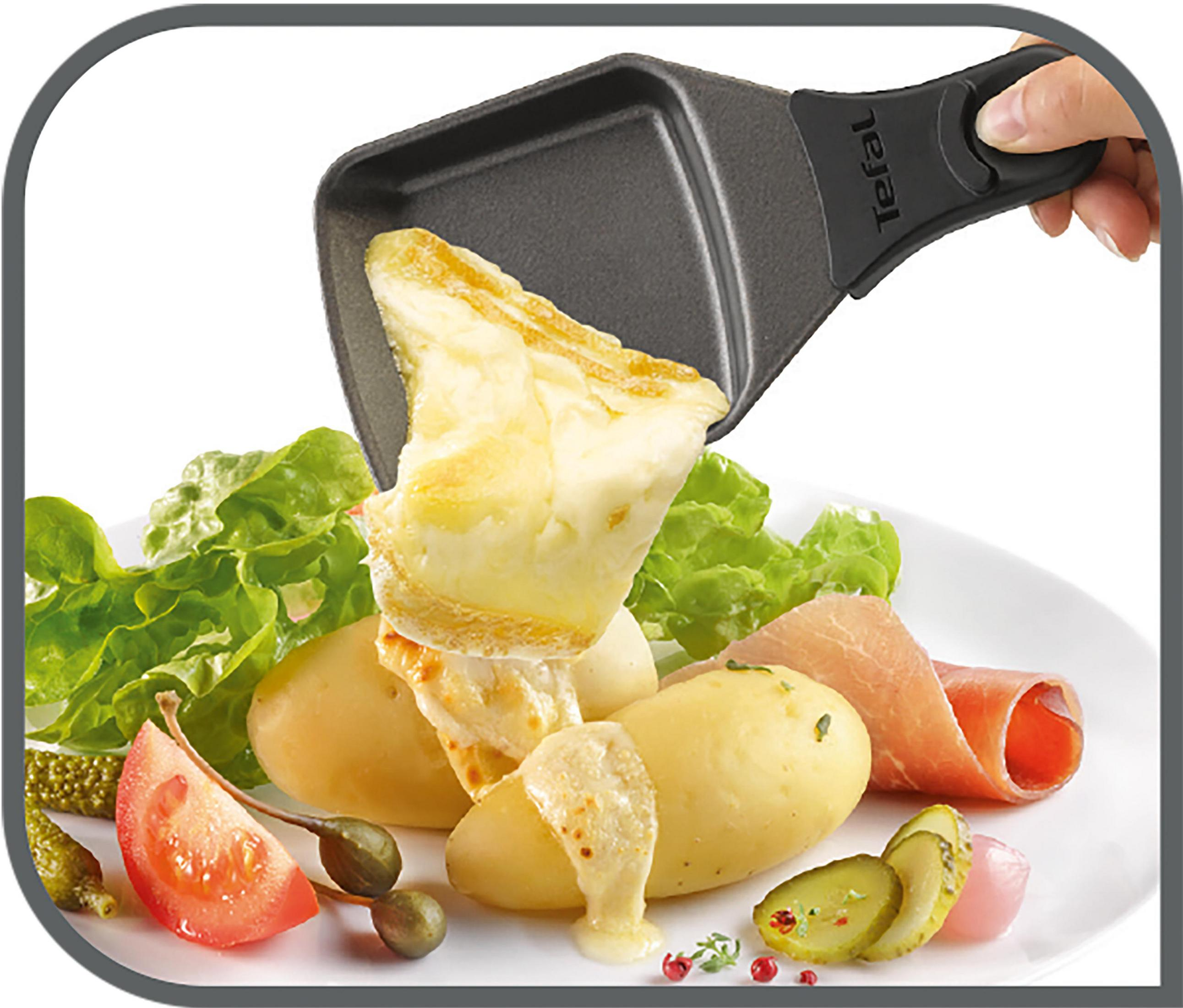 Ręka trzymająca patelnię do raclette wypełnioną roztopionym serem nad ziemniakami i warzywami.