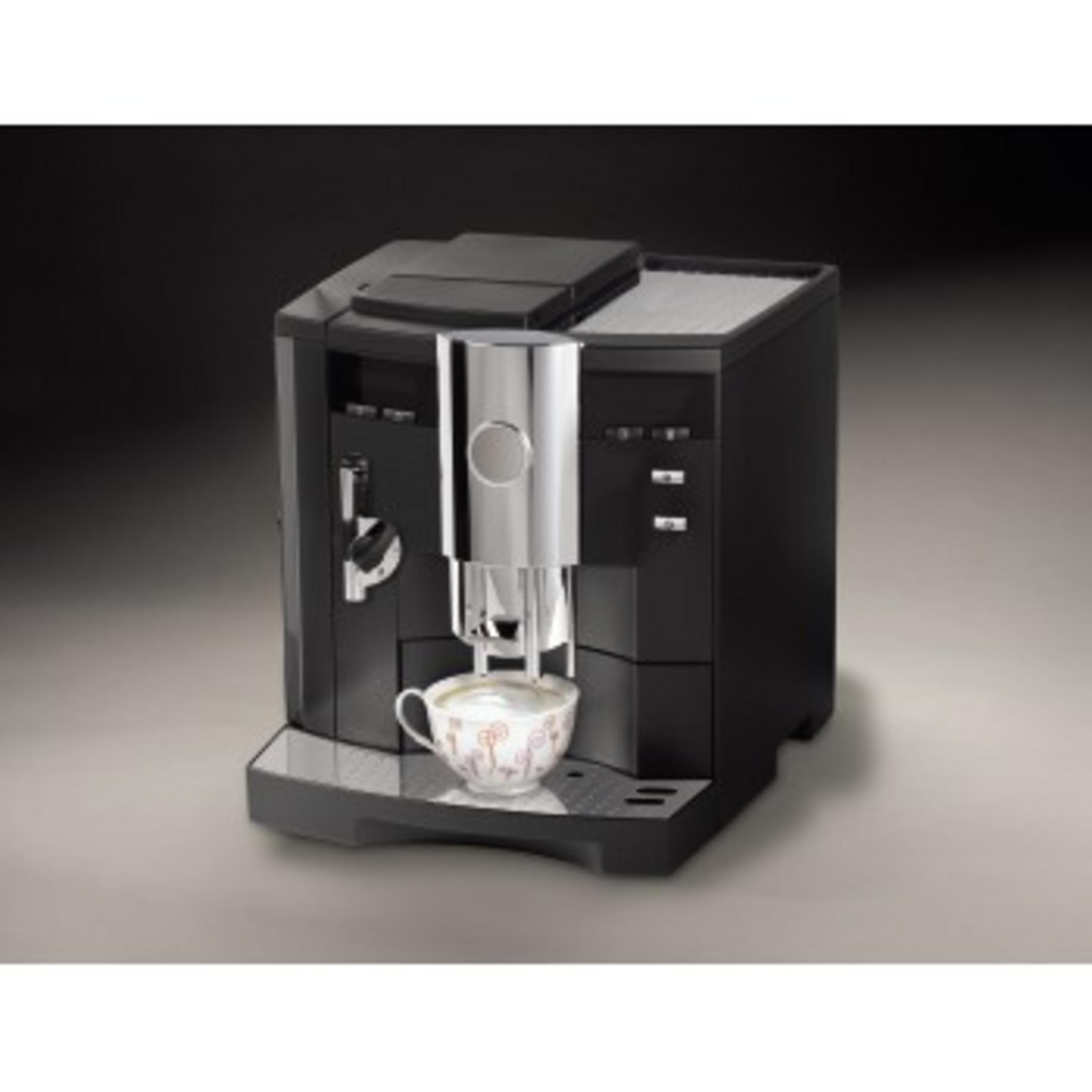Schwarze Kaffeemaschine mit silbernen Akzenten, Tasse unter dem Auslauf, dunkler Hintergrund.