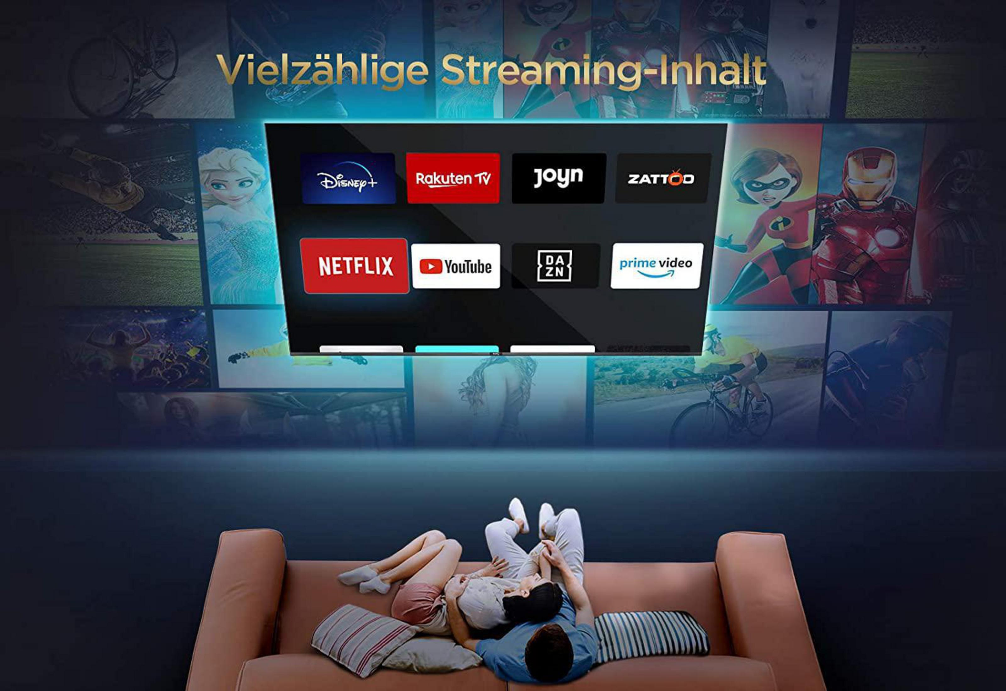 Pareja en un sofá viendo la televisión. La TV muestra iconos de servicios de streaming.