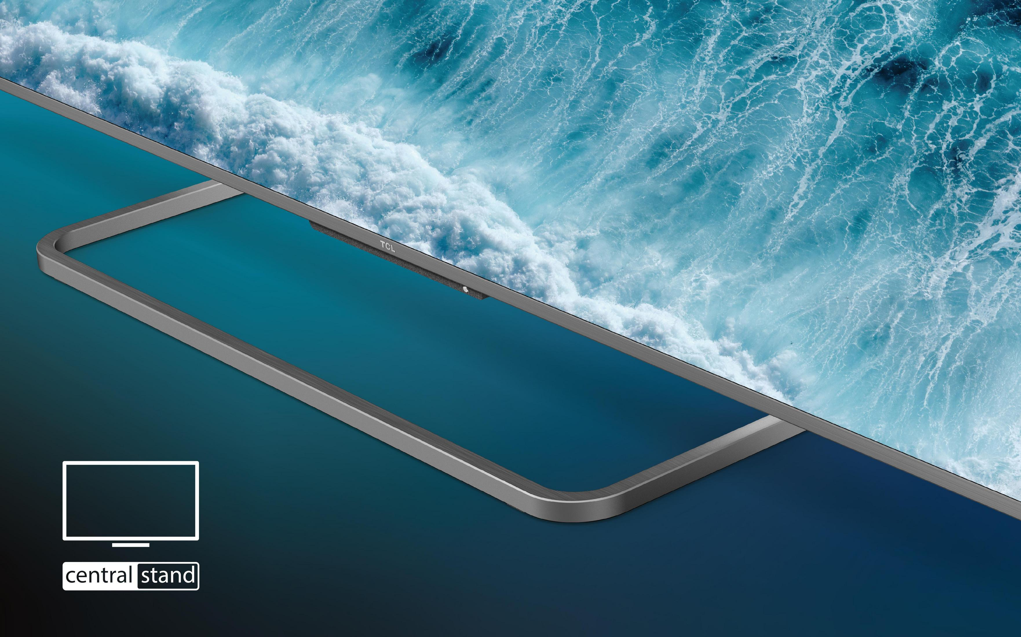 Un écran de télévision montrant une scène de vagues, placé sur un support. Le support est placé sur une surface bleue.