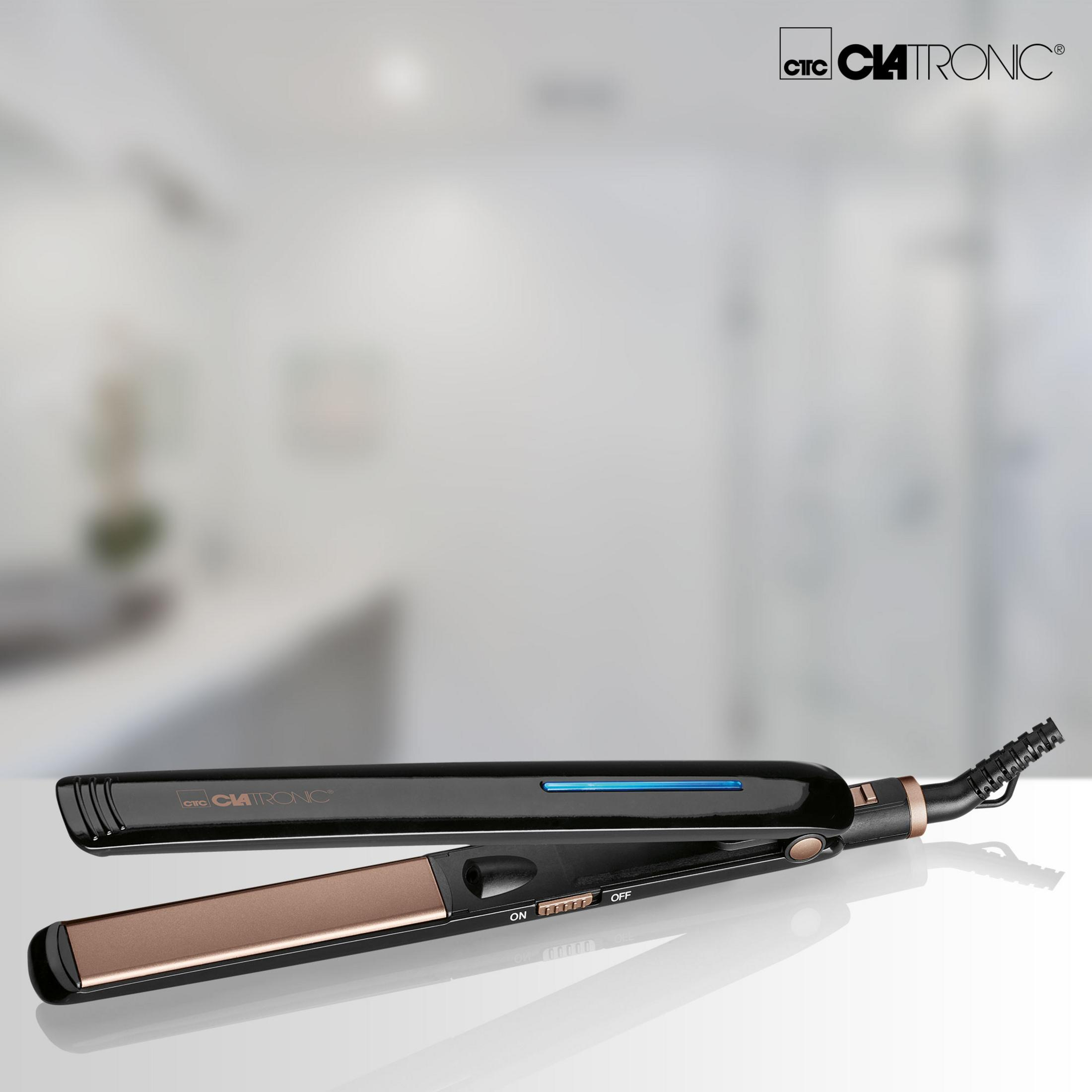 Czarna prostownica do włosów na białej powierzchni. Tło to rozmyta łazienka.