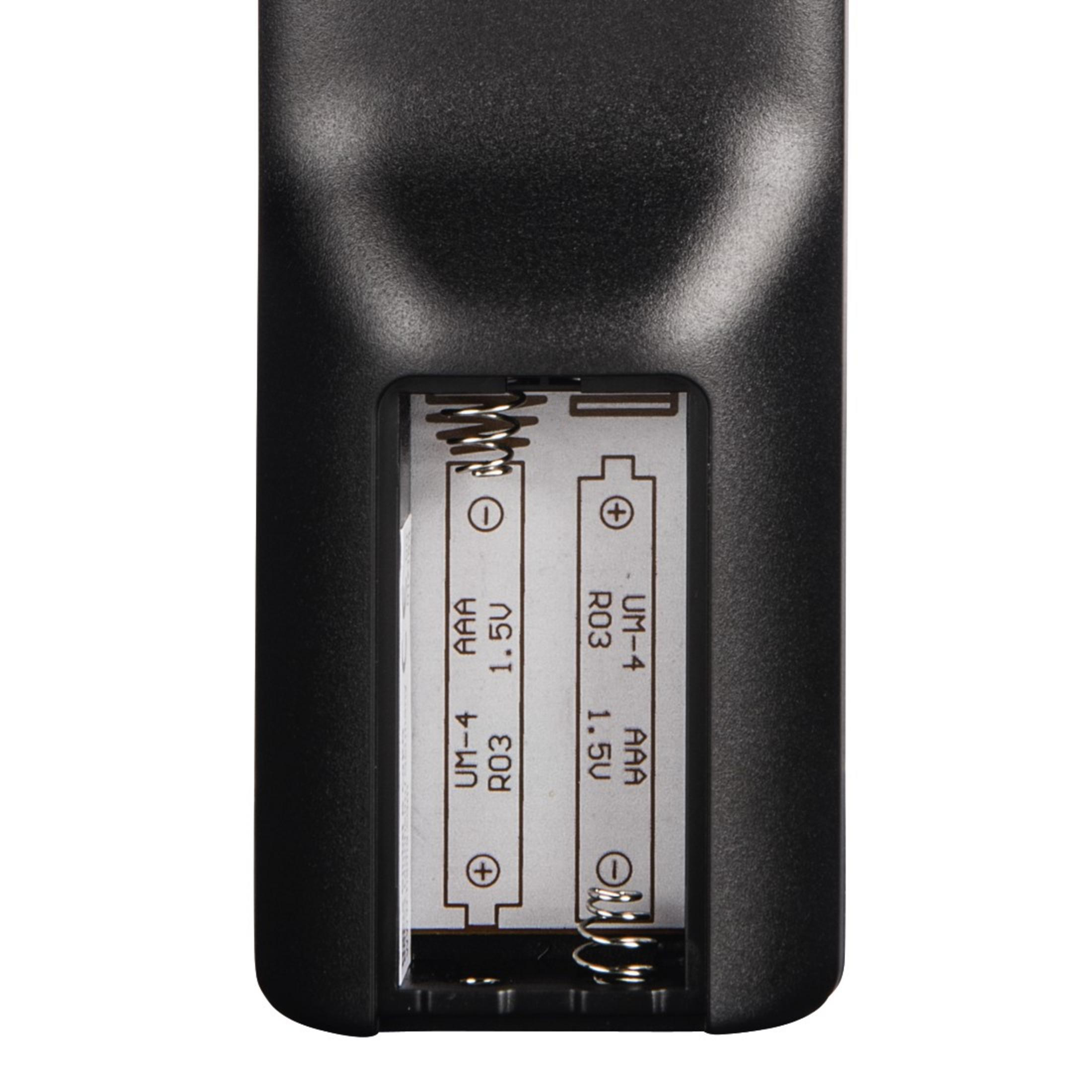 Widok z bliska na tył czarnego pilota z otwartymi przegrodami na baterie.