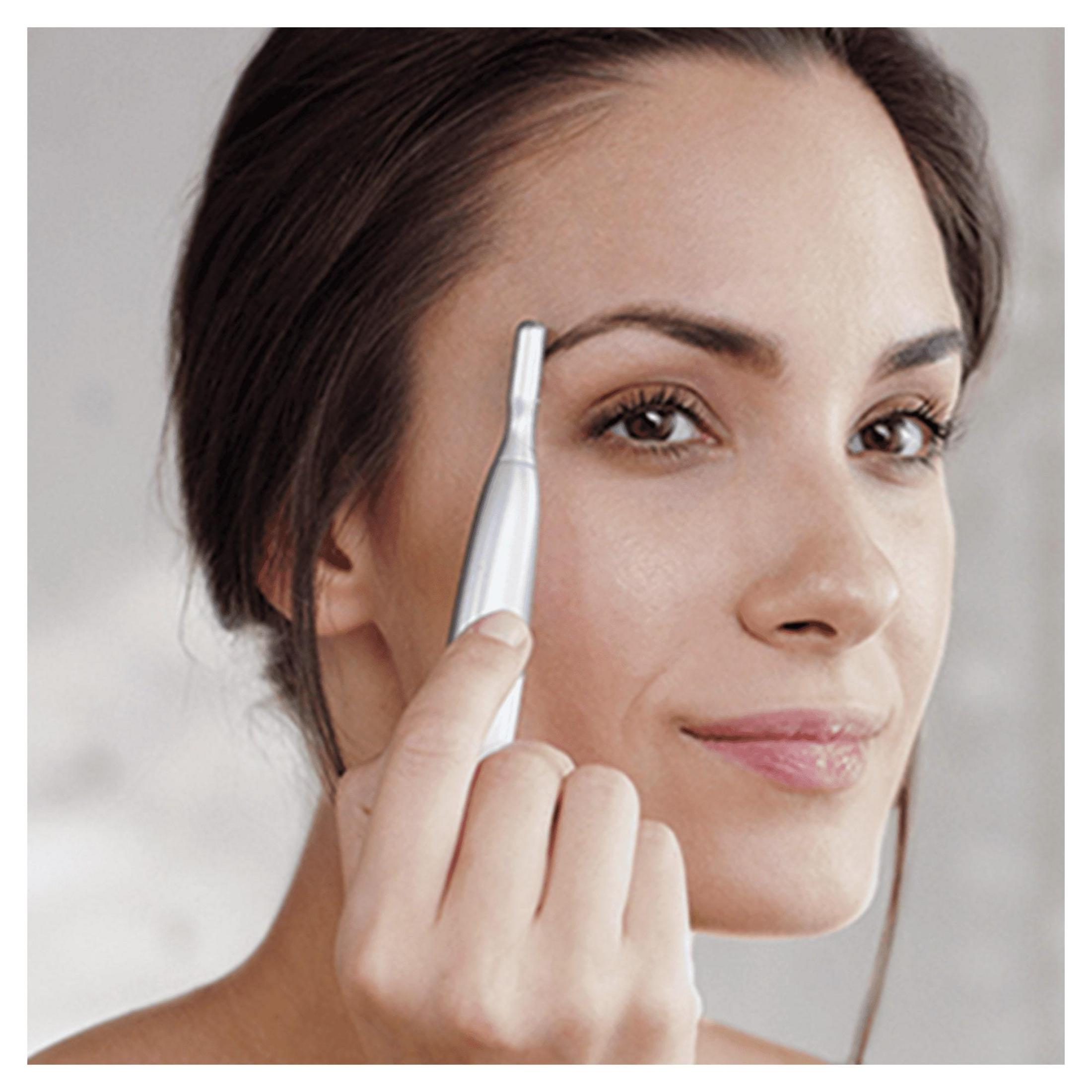 Kobieta używająca urządzenia do usuwania włosów z twarzy. Uśmiecha się.