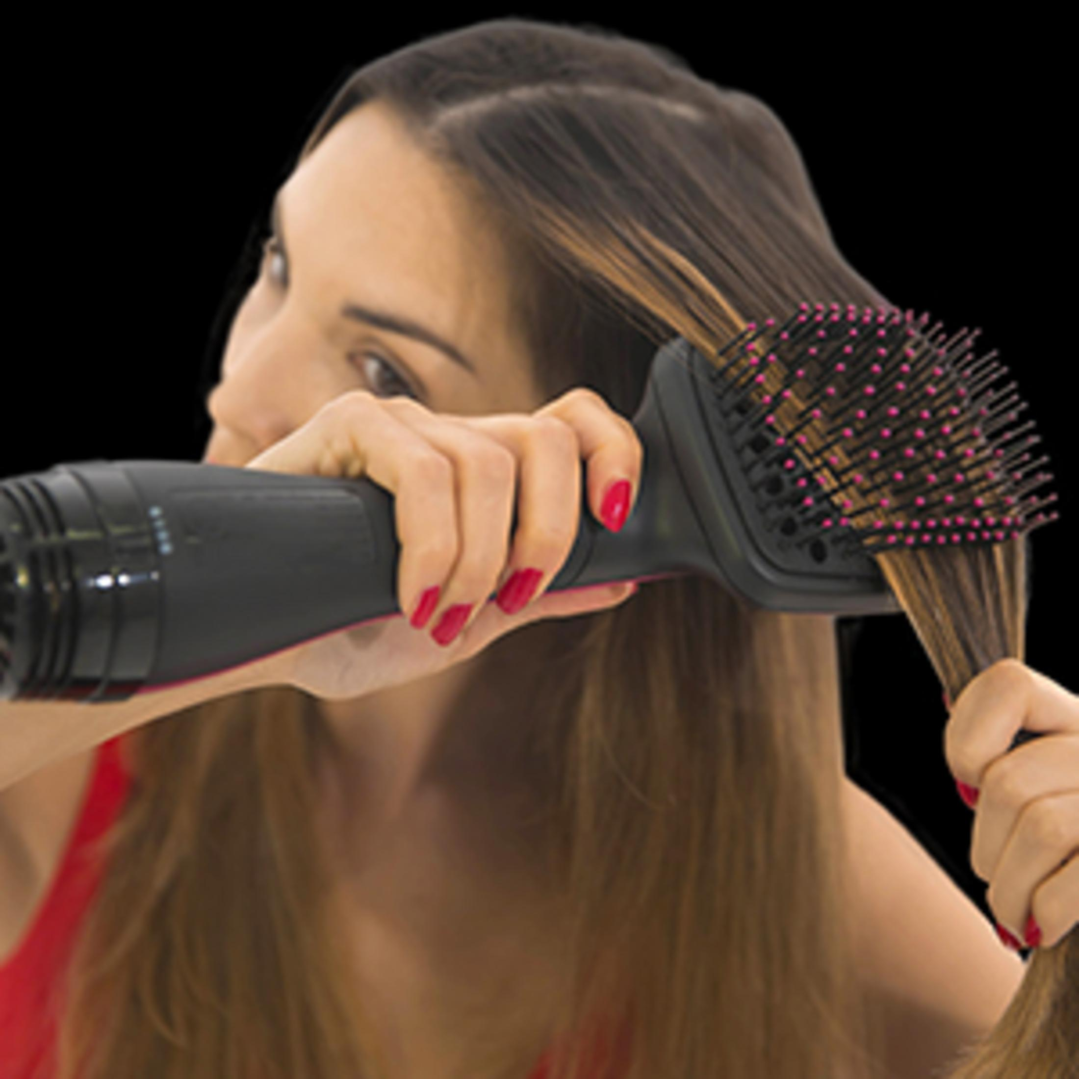 Kobieta używa czarno-różowej szczotki do suszenia włosów na swoich brązowych włosach.