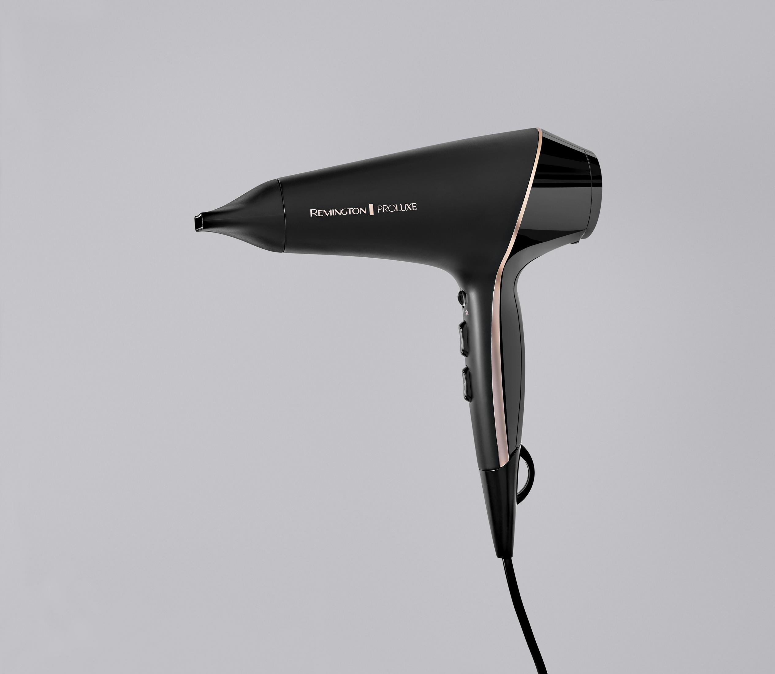 Czarna suszarka do włosów, marka Remington Proluxe, na szarym tle. Suszarka ma złote akcenty.