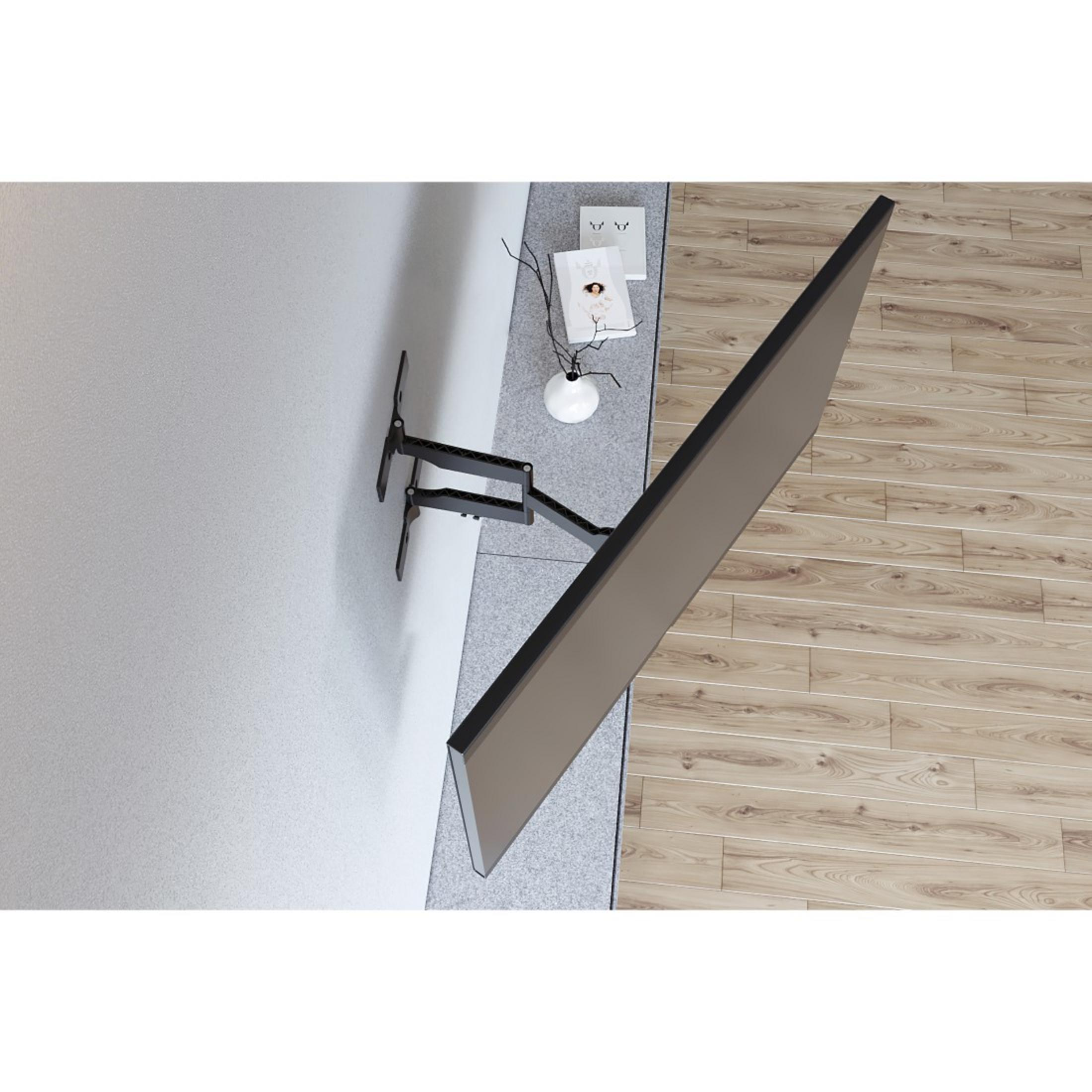 Telewizor zamontowany na ścianie z obrotowym ramieniem. Ściana jasnoszara, podłoga drewniana.