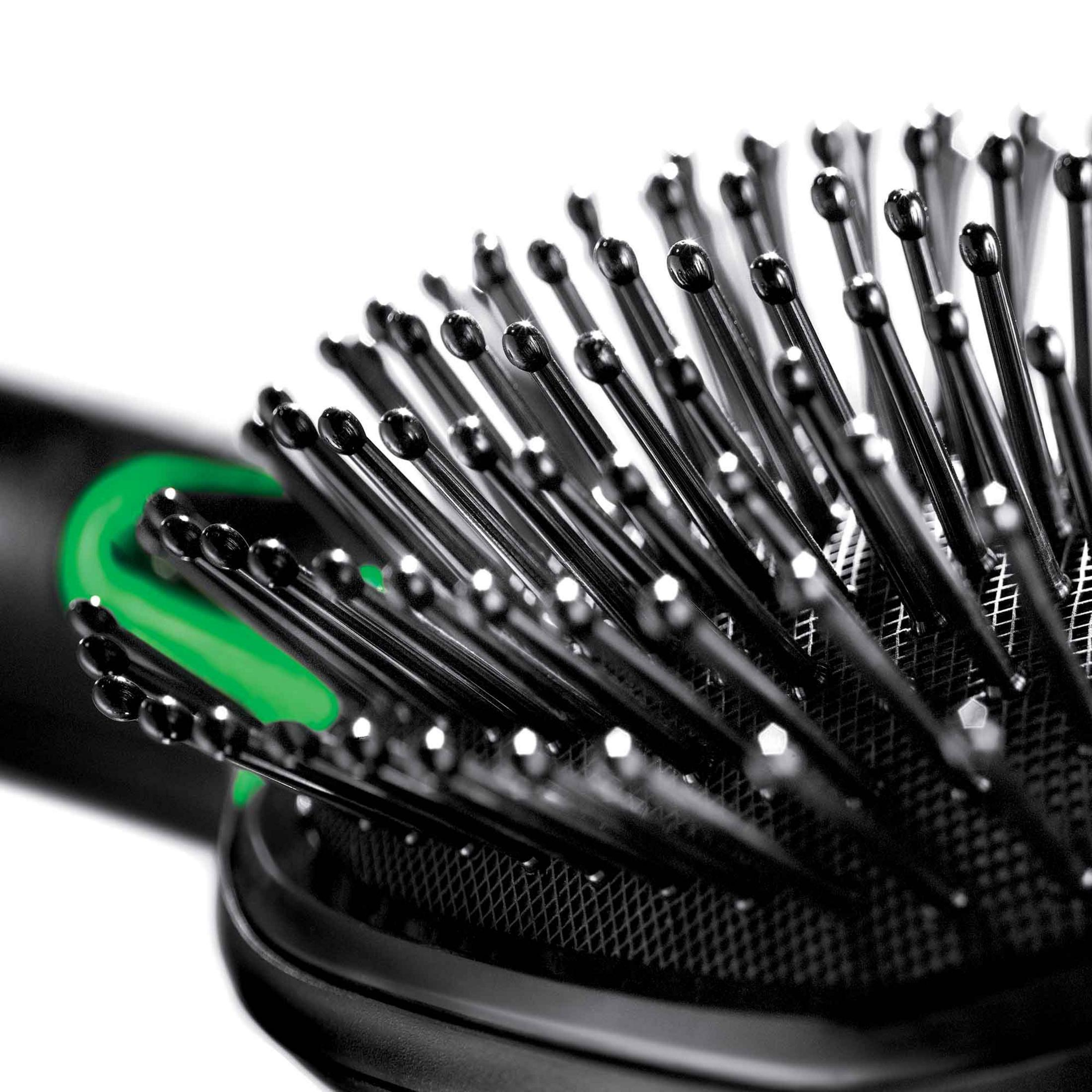Nahaufnahme einer schwarzen Haarbürste mit grünen Details.