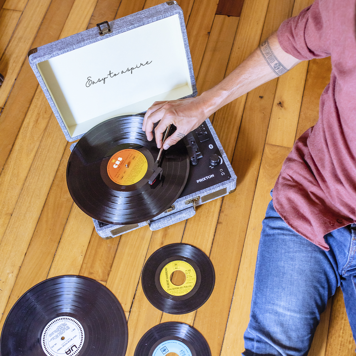 Osoba umieszczająca igłę na płycie winylowej na zabytkowym gramofonie.