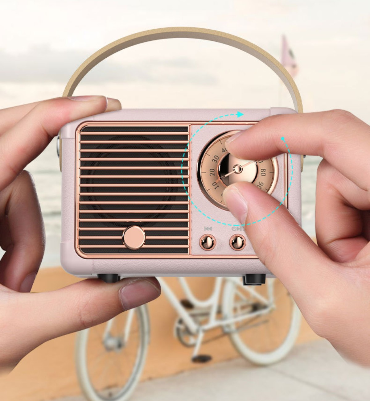 Eine Person stellt den Drehregler an einem rosa Radio im Retro-Stil ein. Im Hintergrund ein Fahrrad.