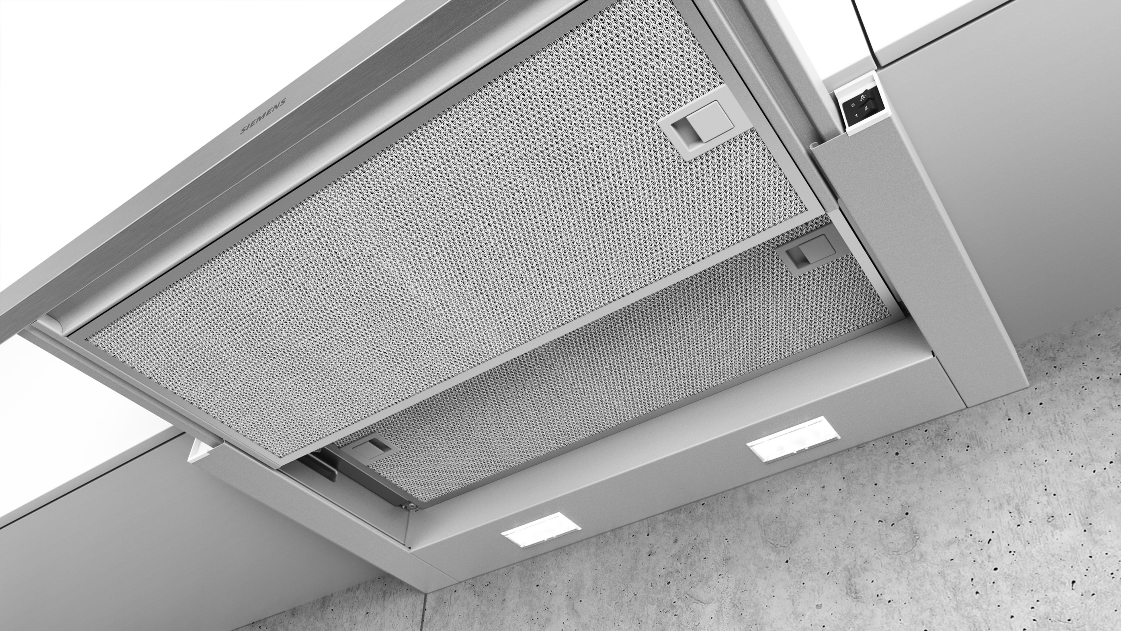 Okap ze stali nierdzewnej zamontowany pod białą szafką.