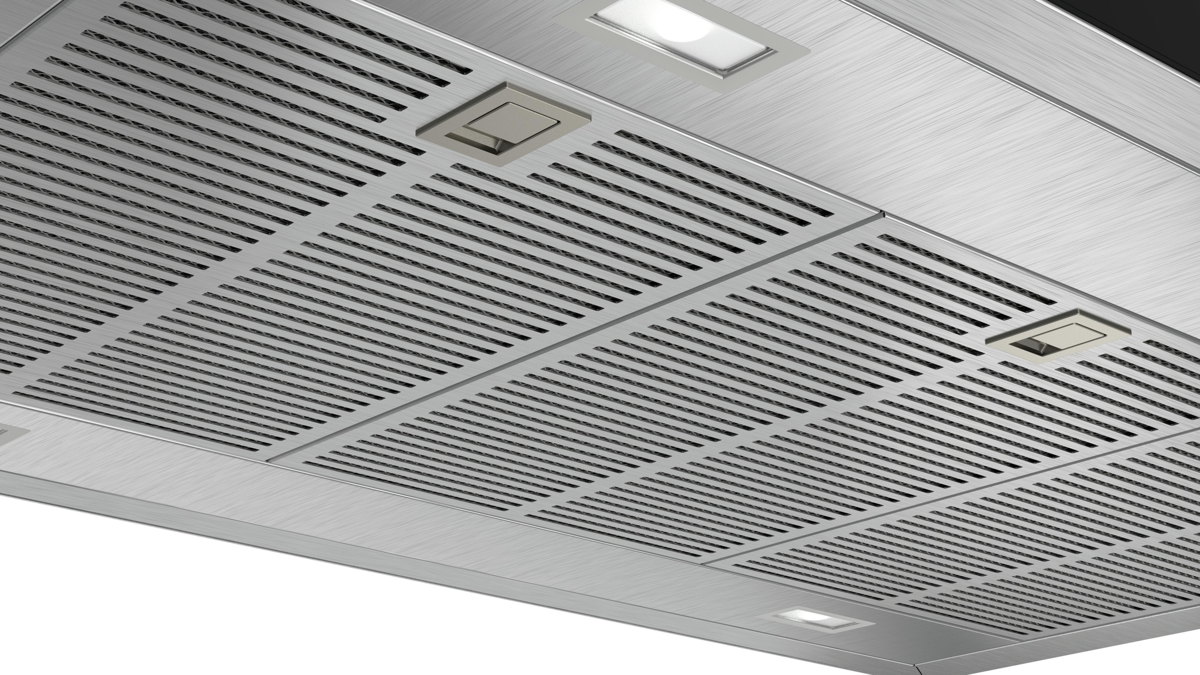 Hotte de cuisine en acier inoxydable avec grille et lumières, vue en angle.