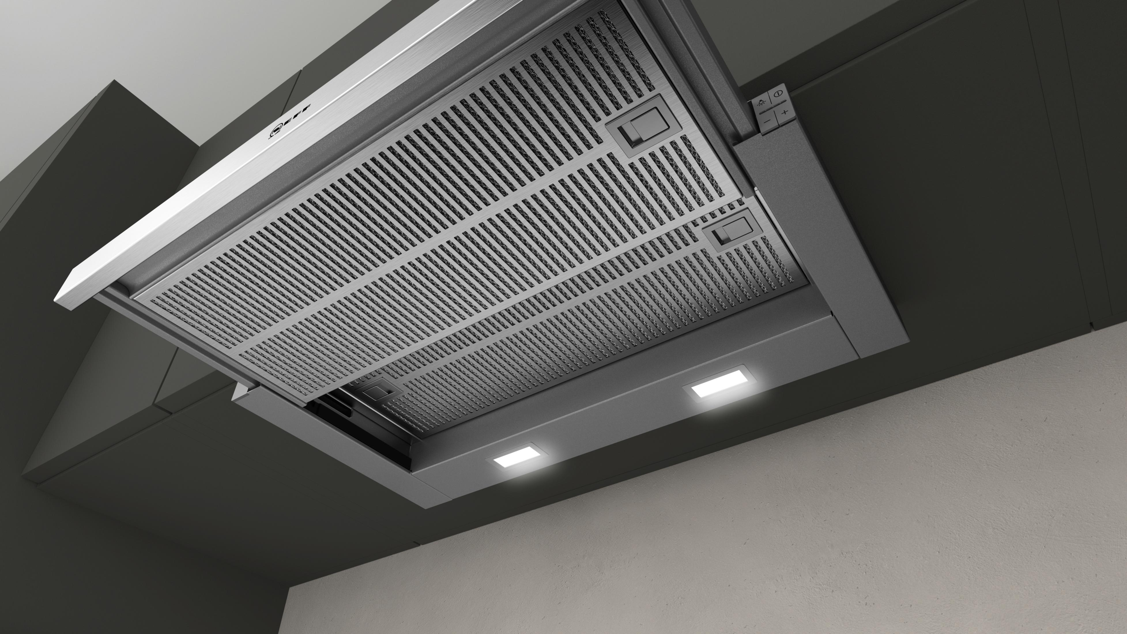 Cappa in acciaio inox montata su soffitto scuro, con luci.