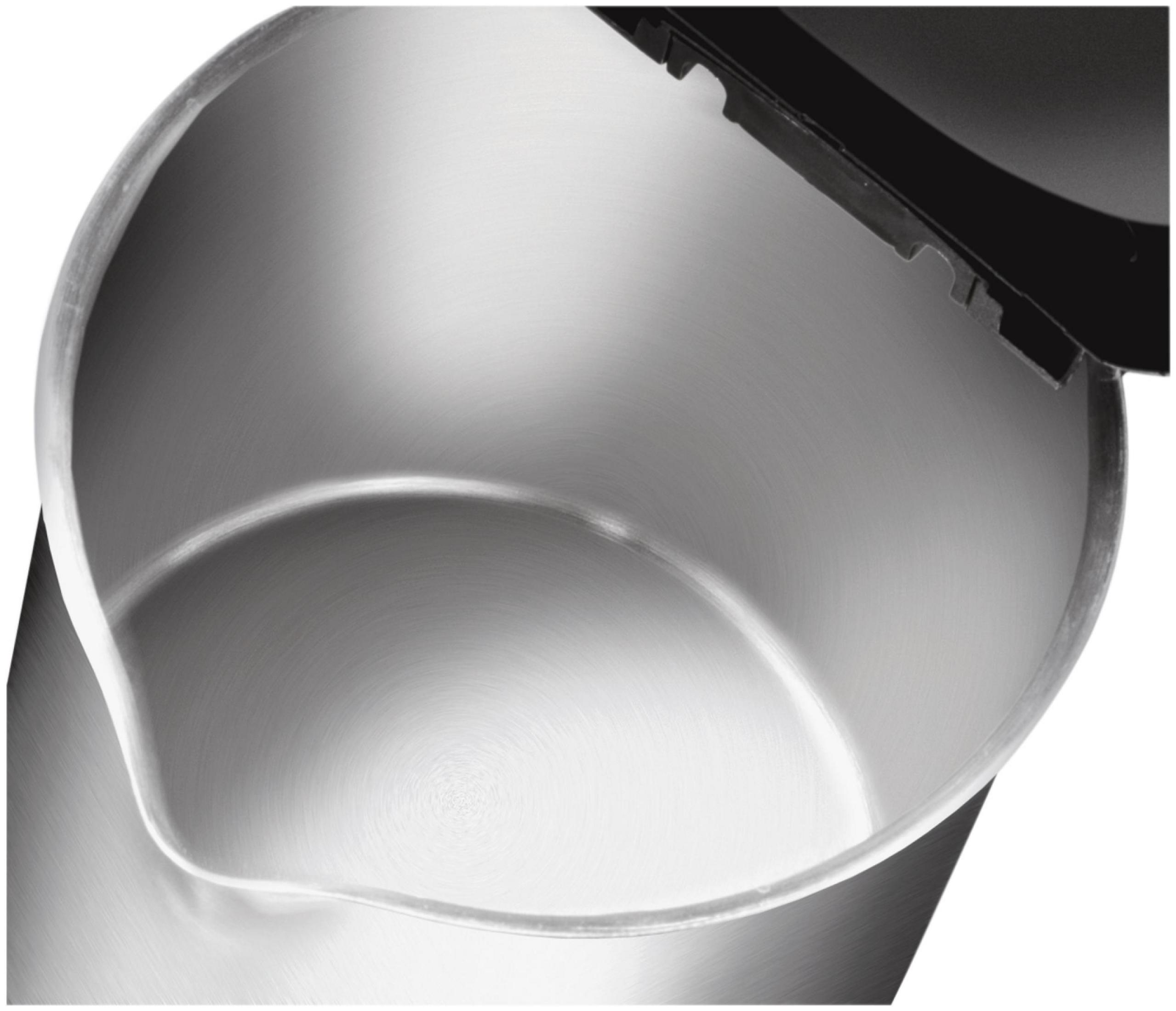 Widok od wewnątrz metalowego czajnika. Wnętrze jest błyszczące i odbijające światło. Otwór jest czarny.