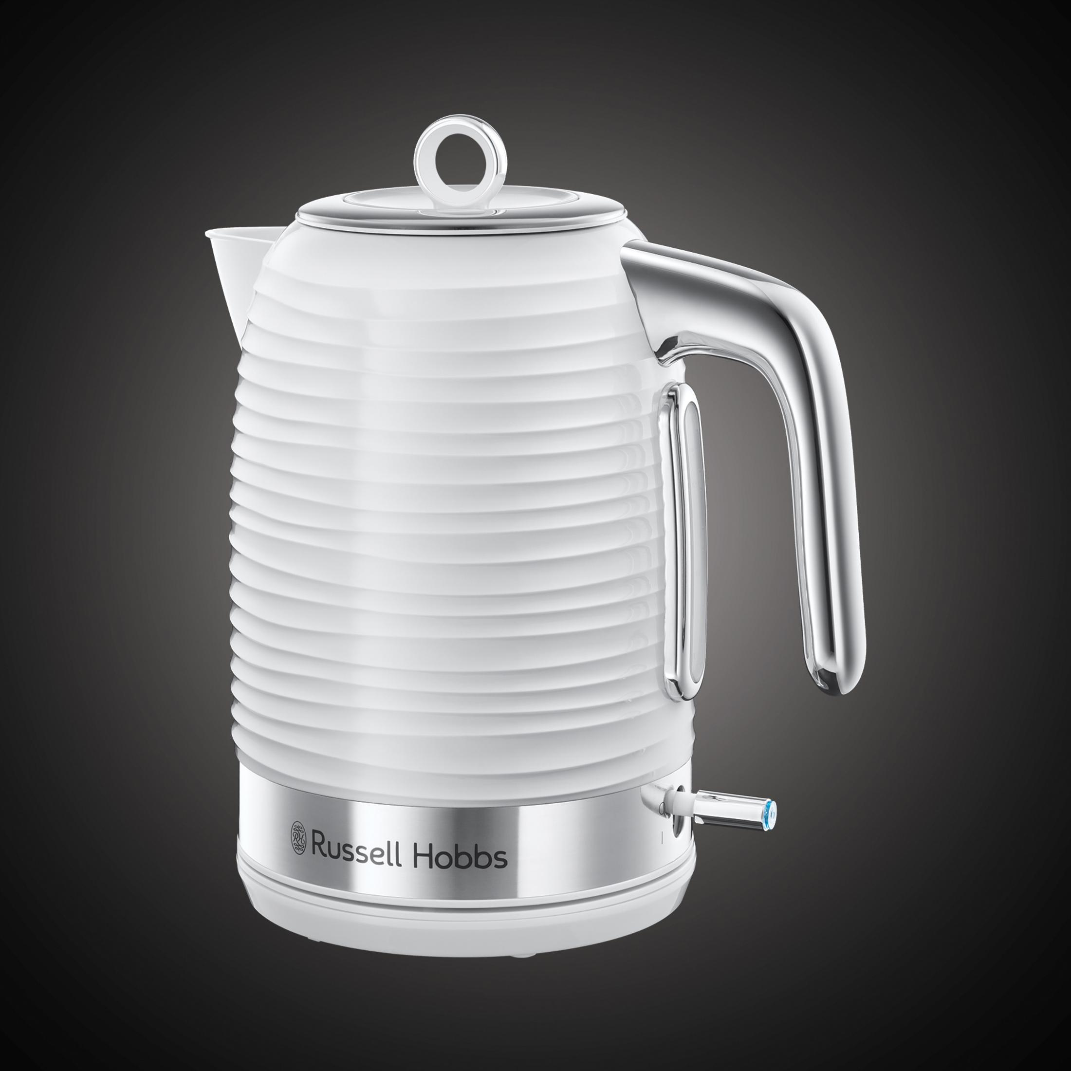 Biały, żebrowany czajnik elektryczny z chromowanym uchwytem i wylewką na ciemnoszarym tle.