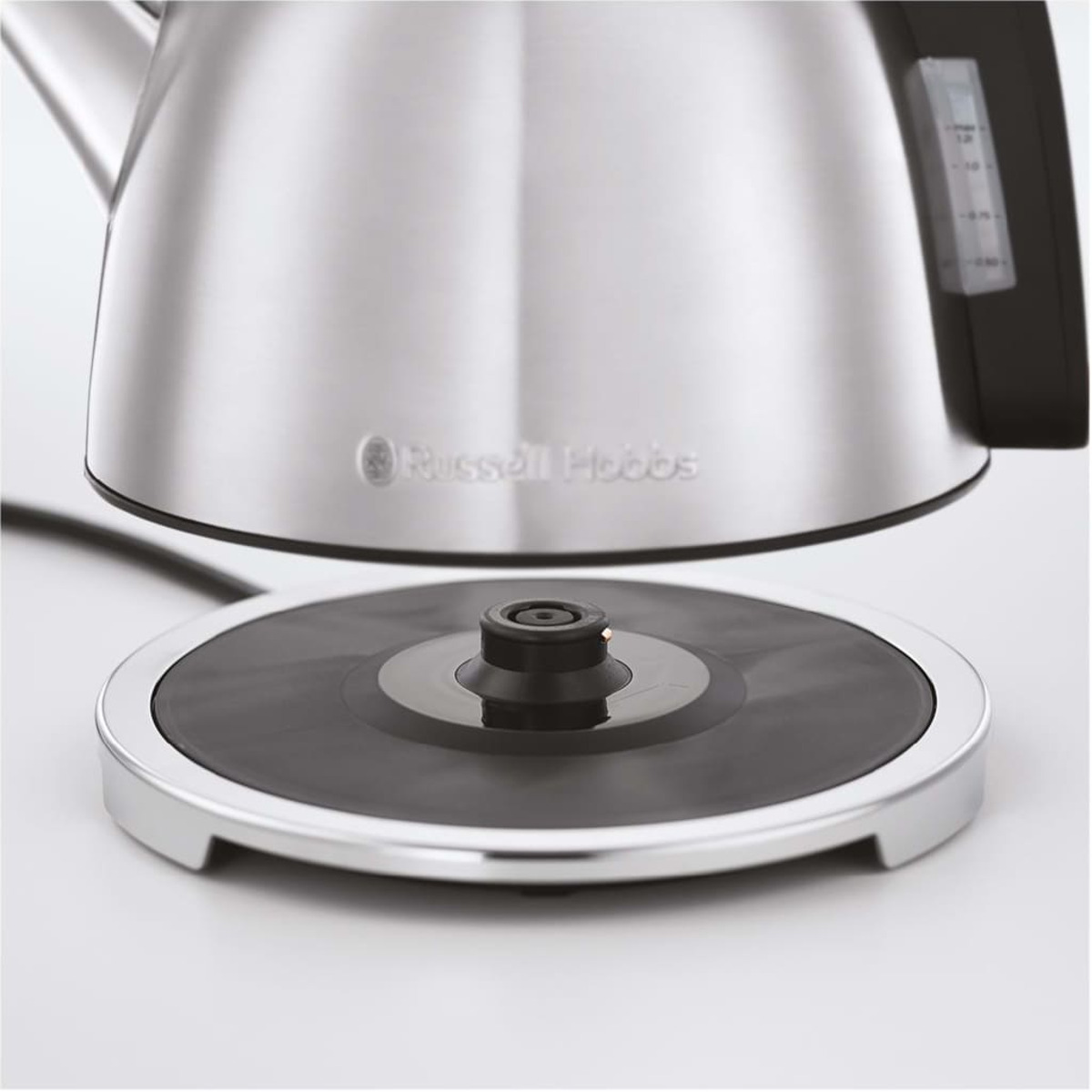 Nahaufnahme eines silbernen Wasserkocherfußes auf einem schwarzen Ständer. Russell Hobbs Logo sichtbar.