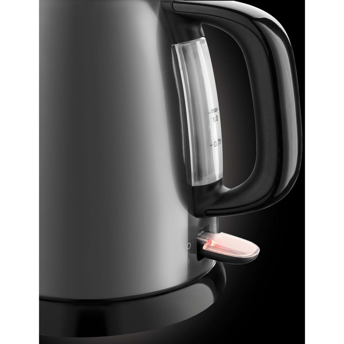 Czajnik elektryczny, czarny z uchwytem. Świeci czerwone światło. Wskaźnik poziomu wody.