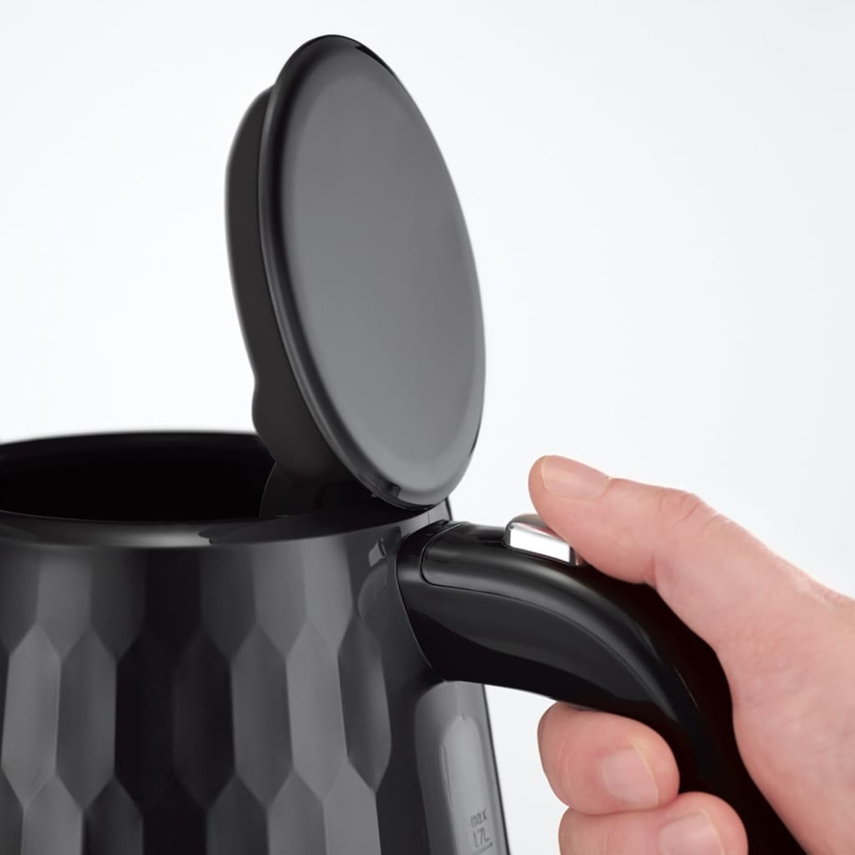 Ein schwarzer Wasserkocher, mit einer Hand, die den Deckel öffnet.