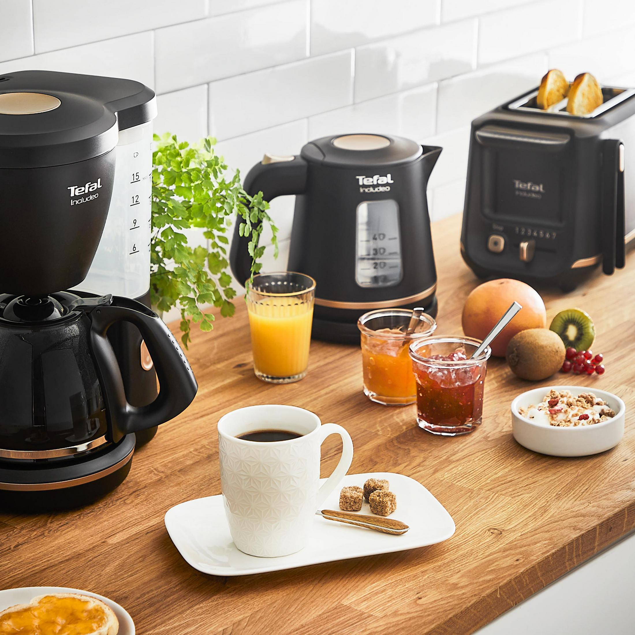 Scena śniadania z kawą, sokiem, dżemem, tostami i urządzeniami na drewnianym blacie. Biały kubek.