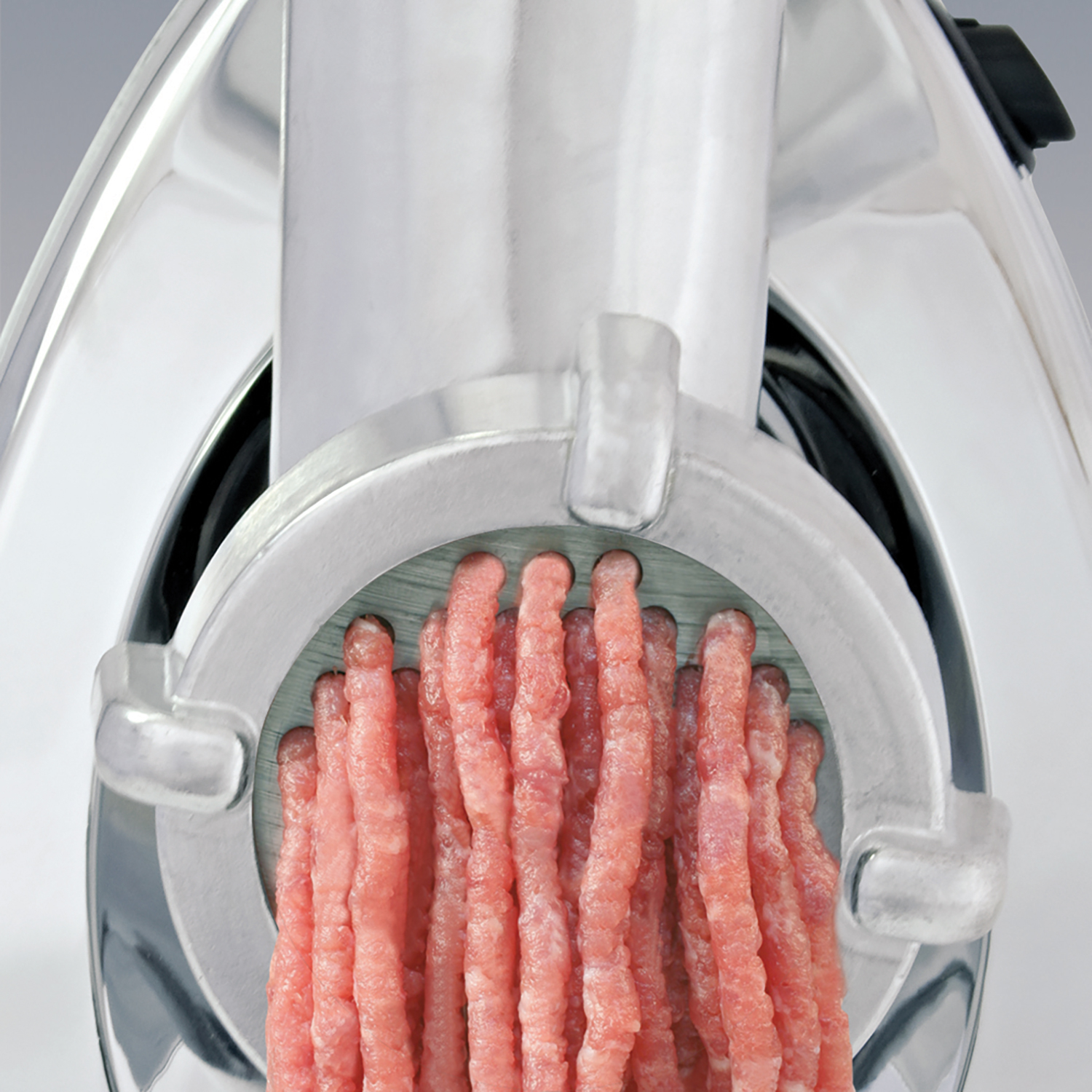 Una picadora de carne con carne picada saliendo de ella.